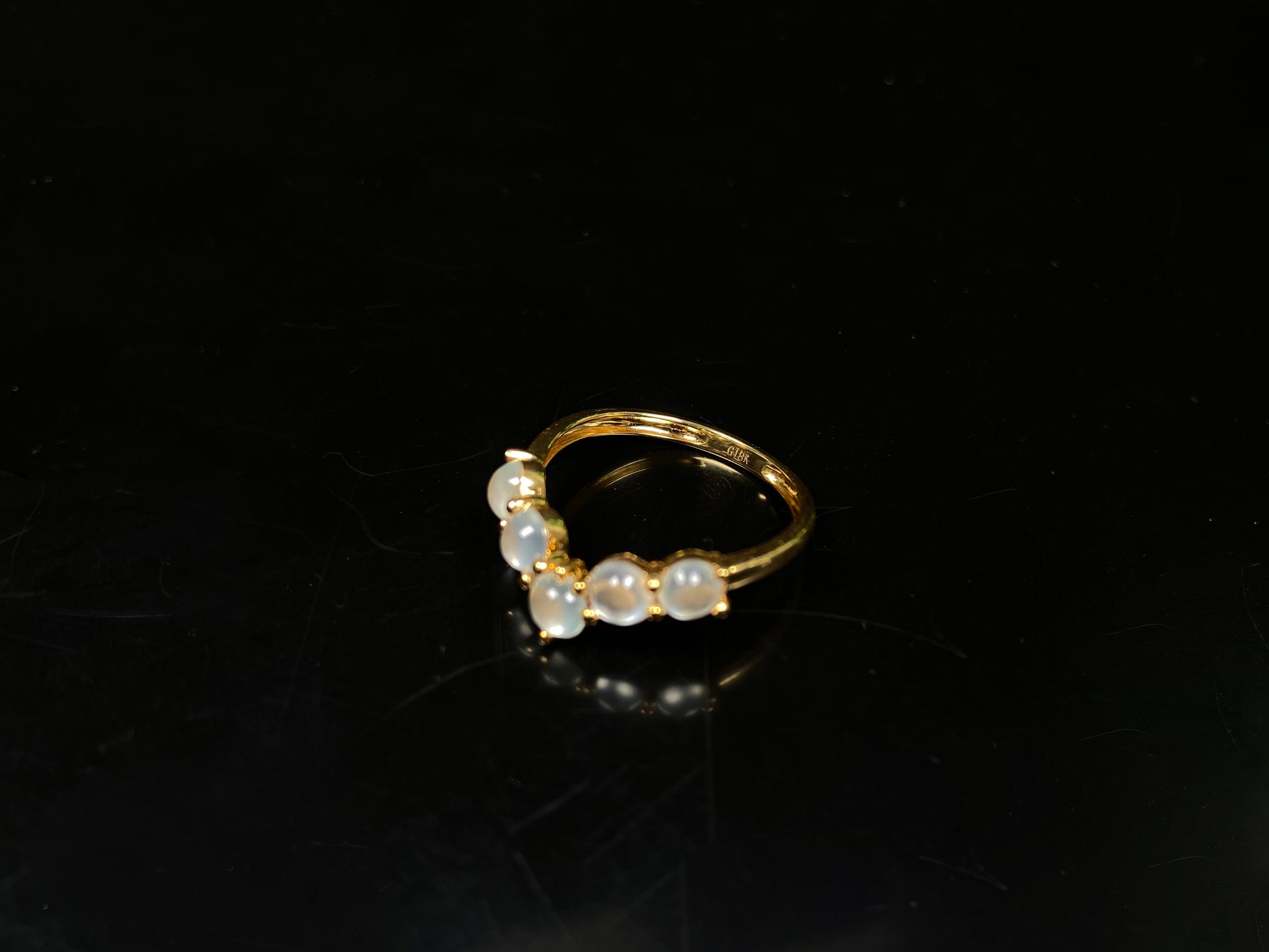 A clear bead cluster crown on gold jadeite ring.