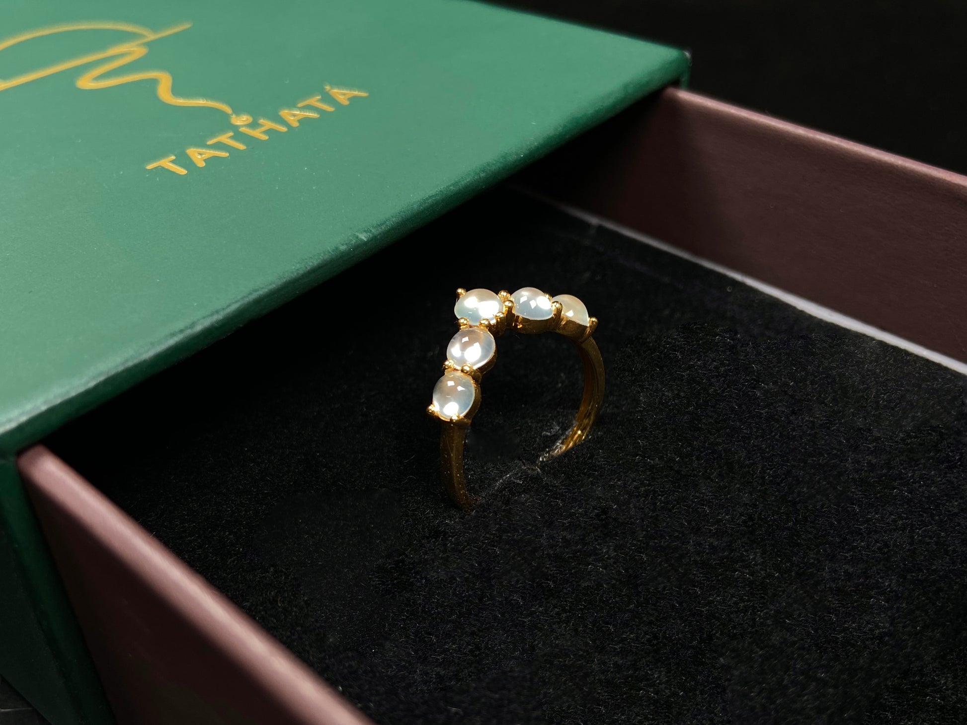 A clear bead cluster crown on gold jadeite ring.