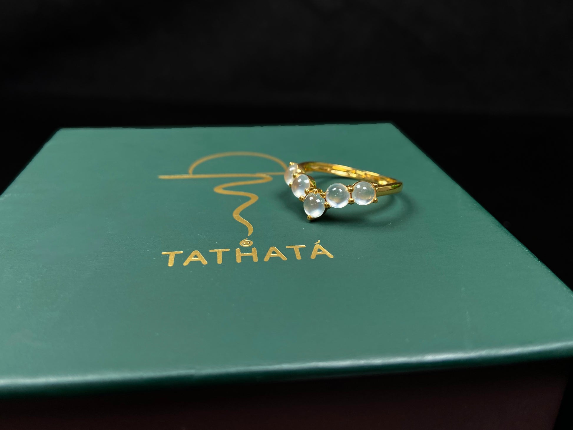 A clear bead cluster crown on gold jadeite ring.