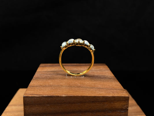 A clear bead cluster crown on gold jadeite ring.