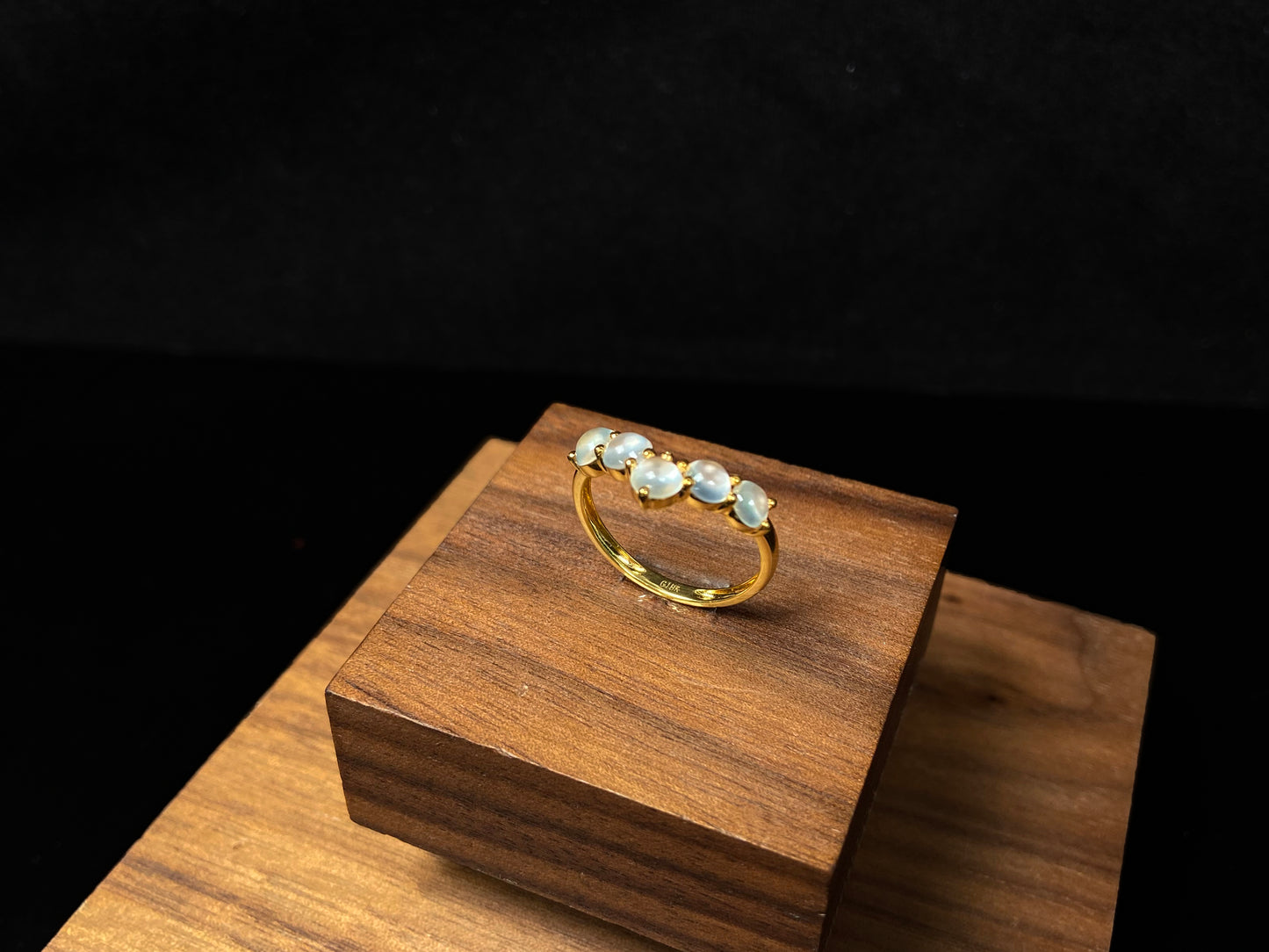 A clear bead cluster crown on gold jadeite ring.