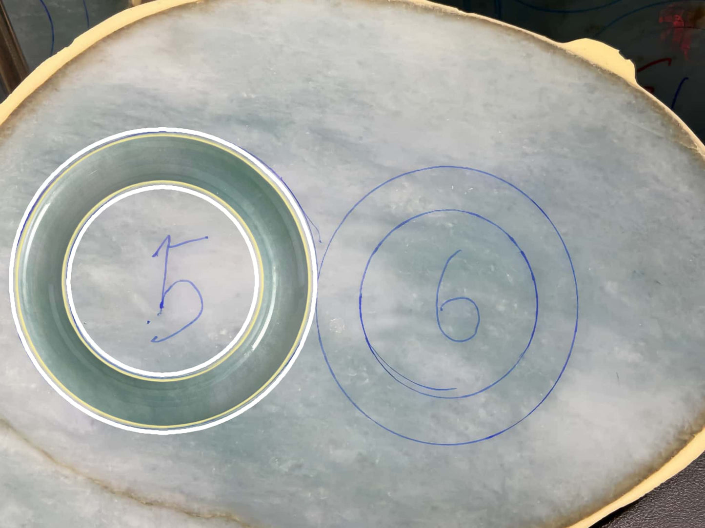 Two circular outlines on a textured surface with numbers '5' and '6'. Multi-purpose Carving of Jadeite Rough Stones & Custom Bangle Services