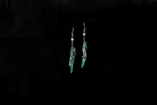 Pair of green earrings on a black background