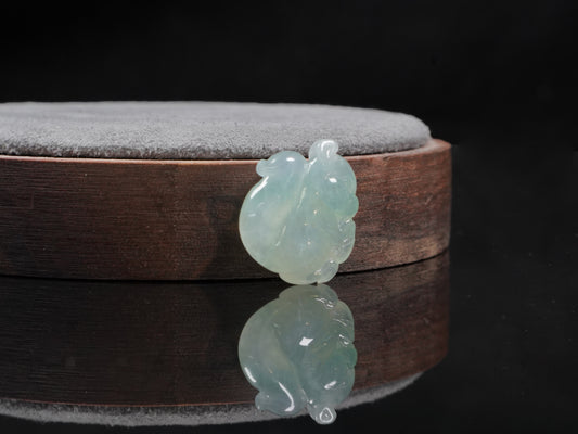 This jadeite carving features a lifelike three-dimensional squirrel rendered in a soft, luminous green with a pale white base.