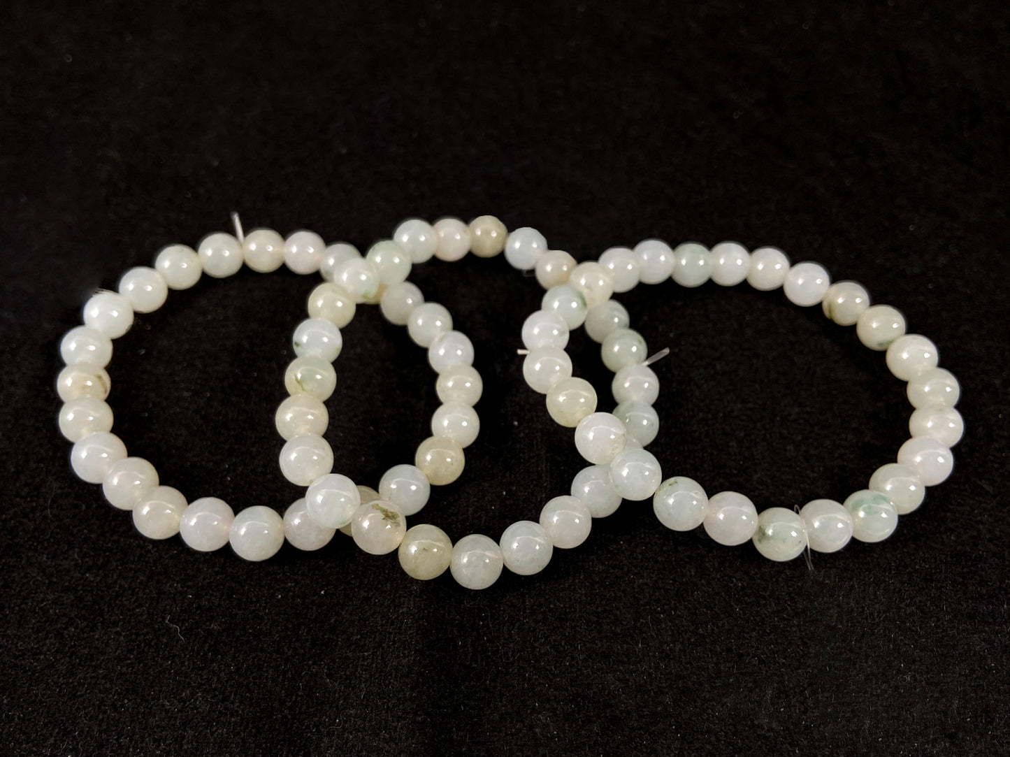 Icy white jade beads with occasional green or brown accents.
