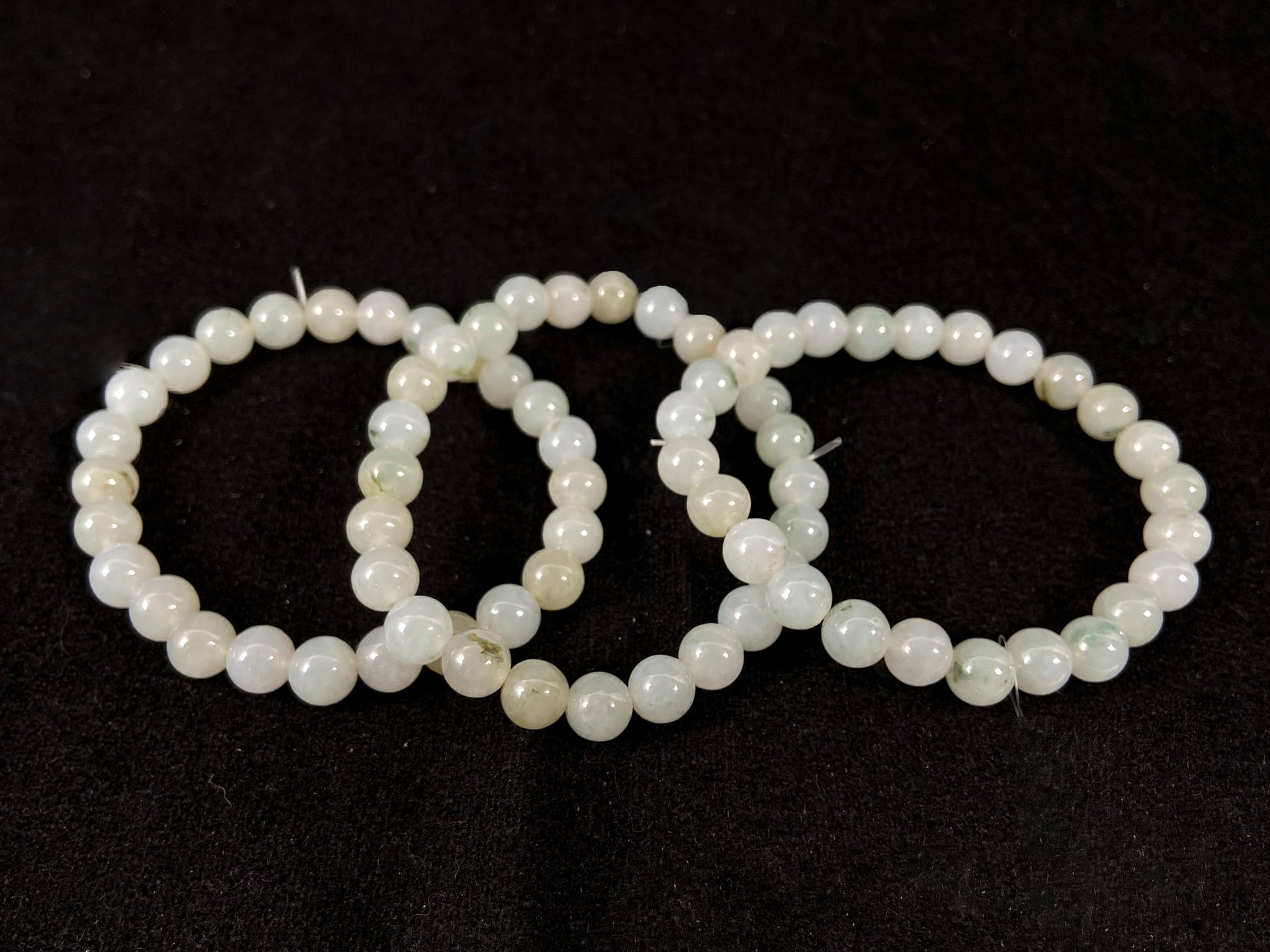 Icy white jade beads with occasional green or brown accents.