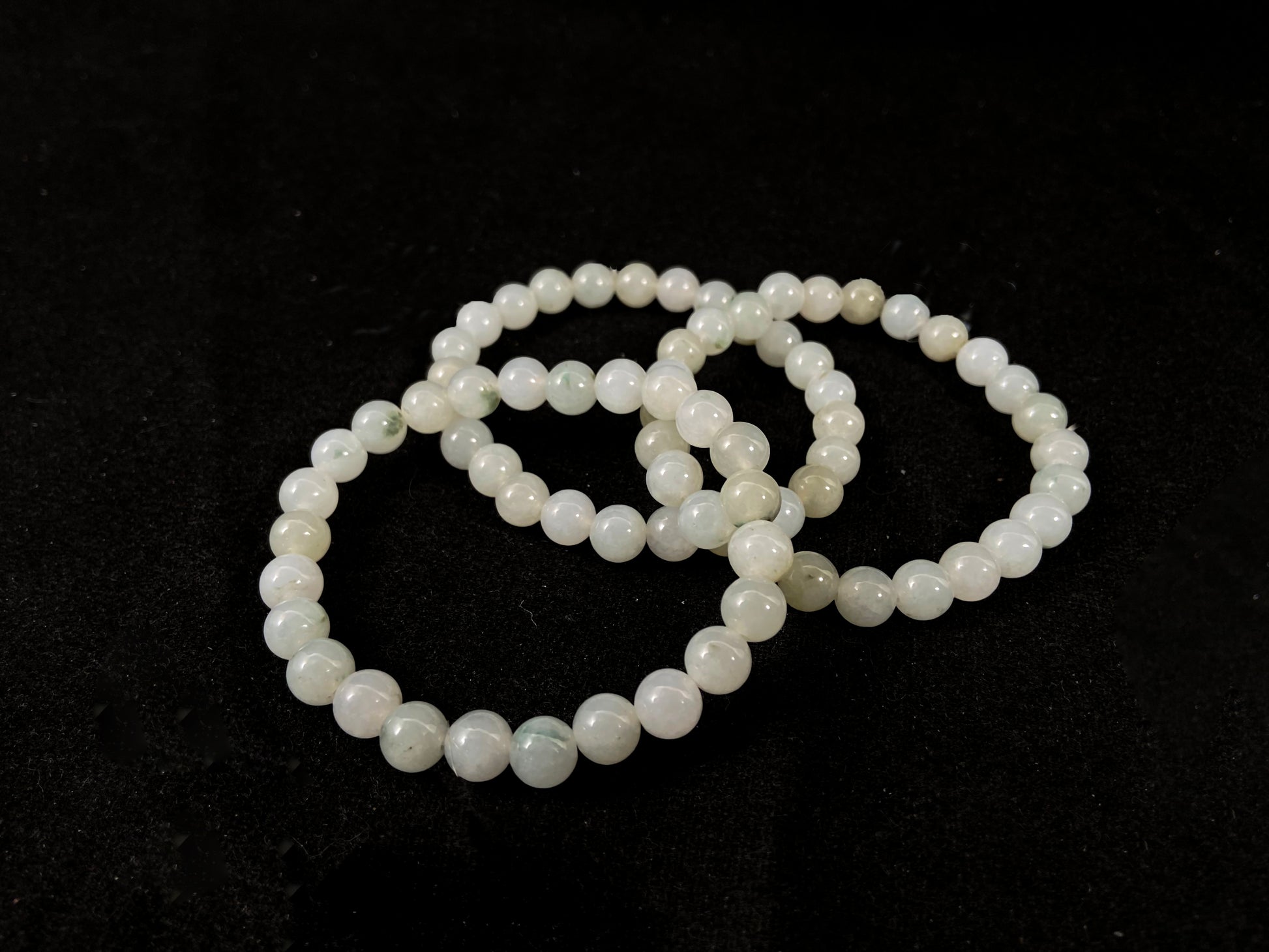 Icy white jade beads with occasional green or brown accents.