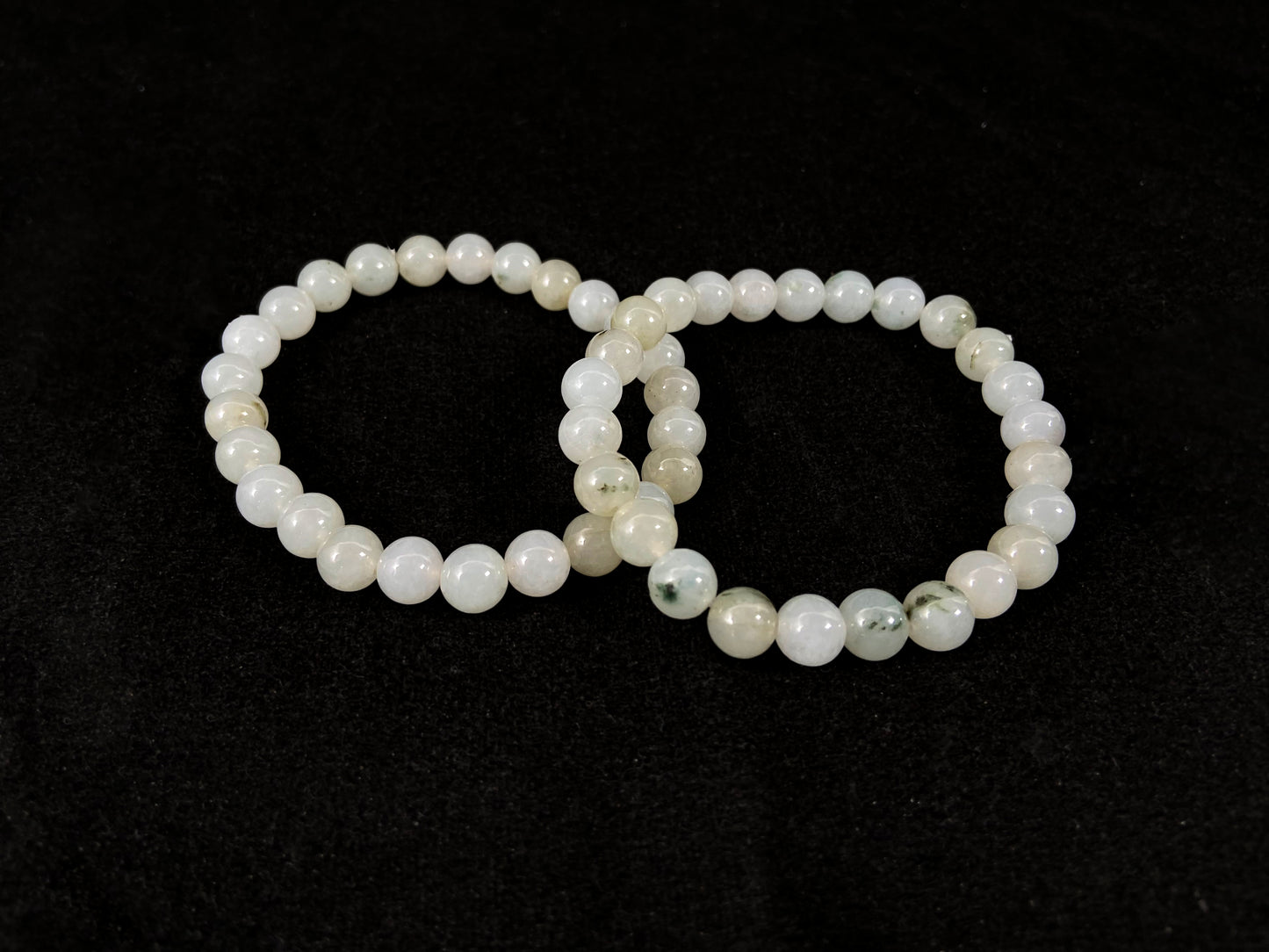 Icy white jade beads with occasional green or brown accents.
