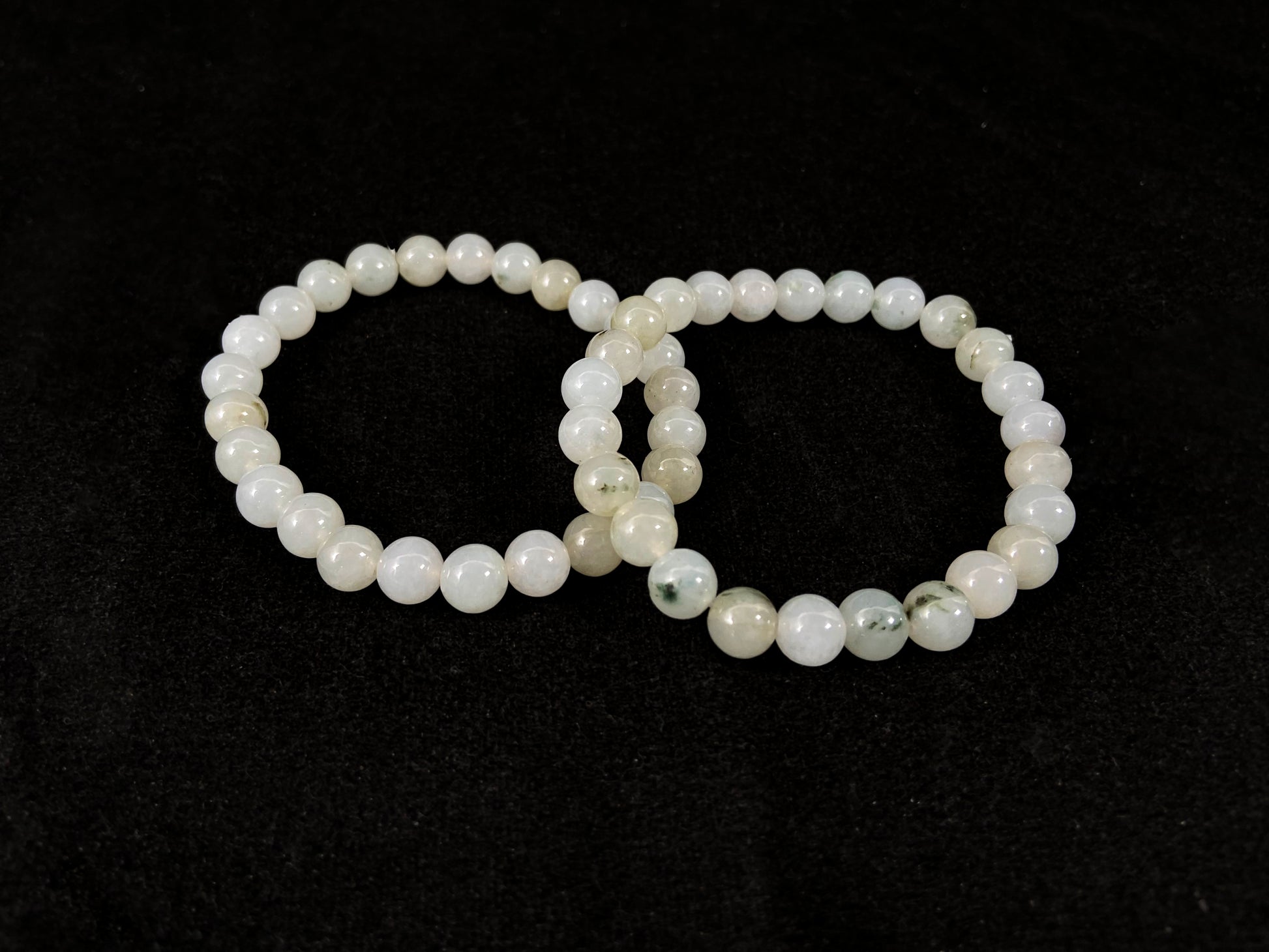 Icy white jade beads with occasional green or brown accents.