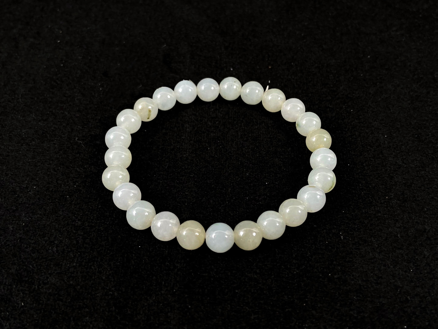 Icy white jade beads with occasional green or brown accents.