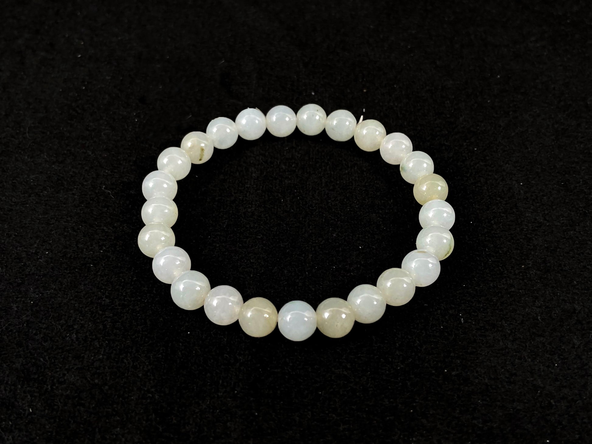 Icy white jade beads with occasional green or brown accents.