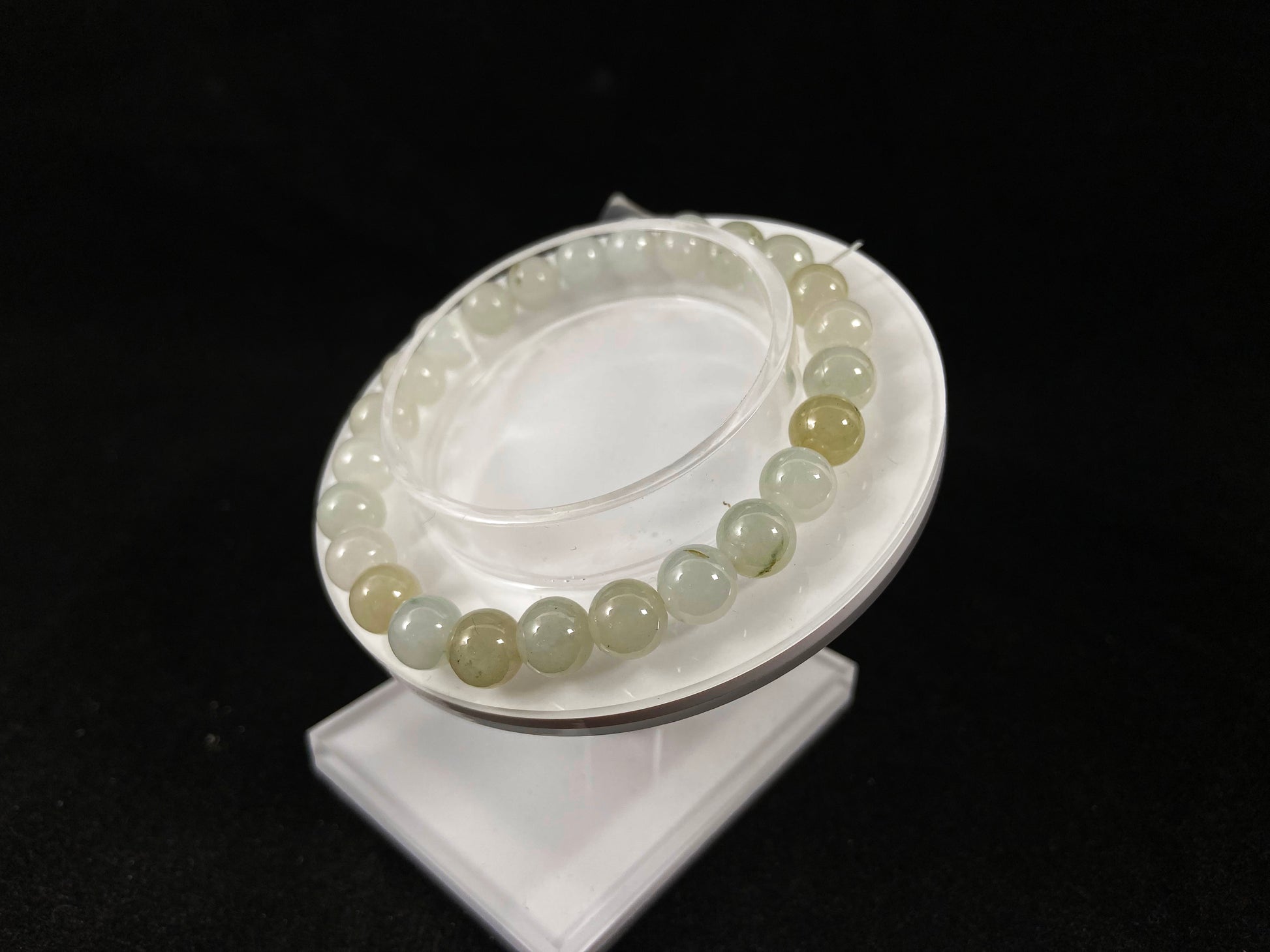 Icy white jade beads with occasional green or brown accents.