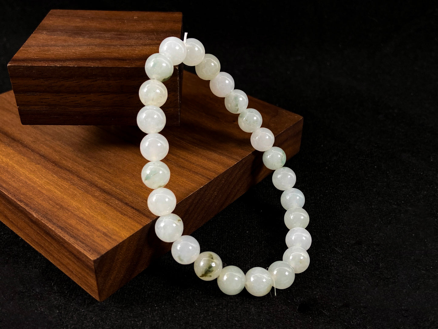 Icy white jade beads with occasional green or brown accents.