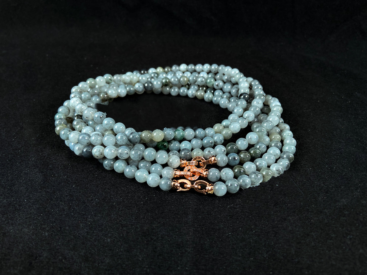 Semi transparent jade beads with unique gray accents, deep green stones, and alloy clasp.