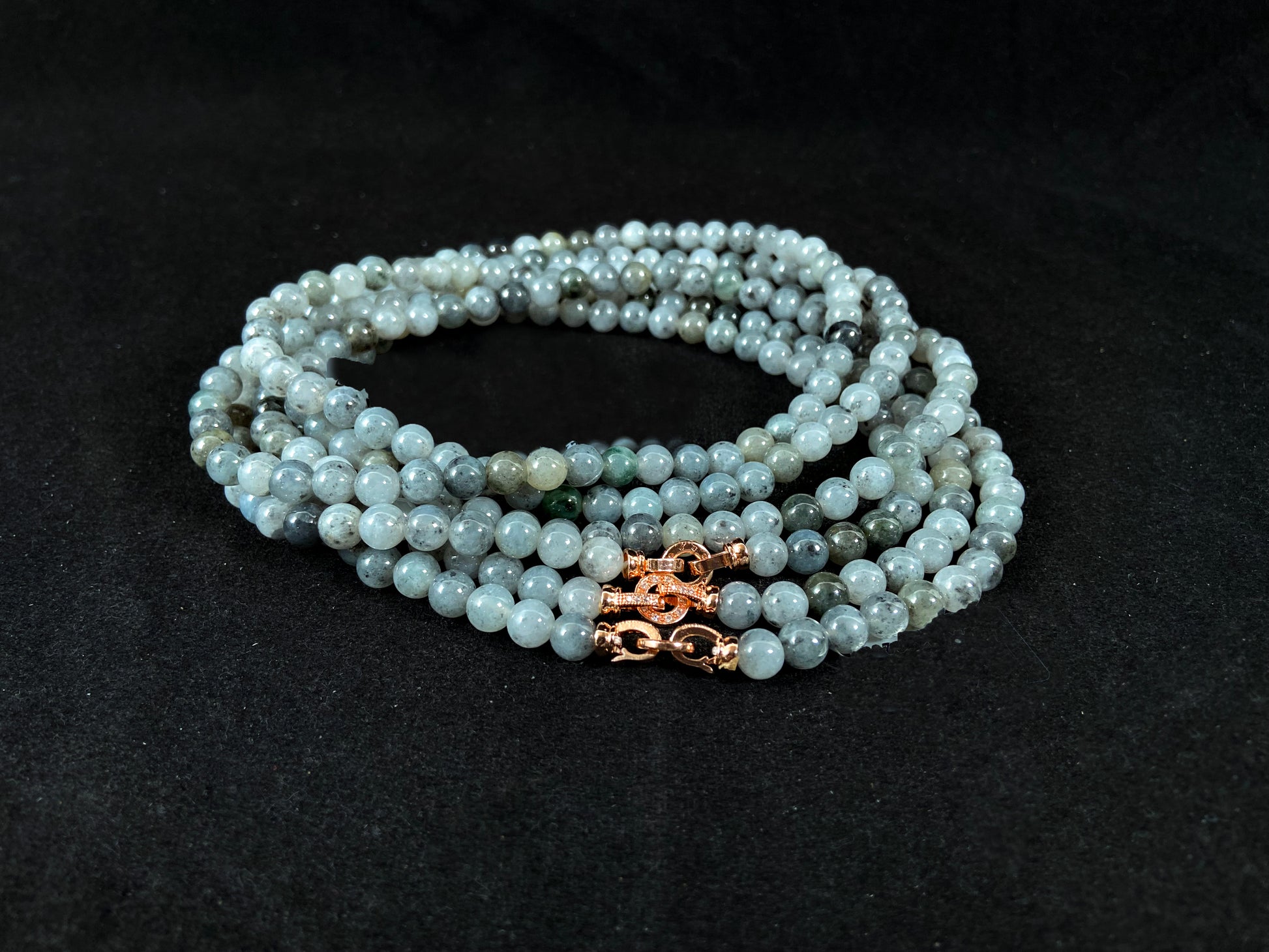 Semi transparent jade beads with unique gray accents, deep green stones, and alloy clasp.