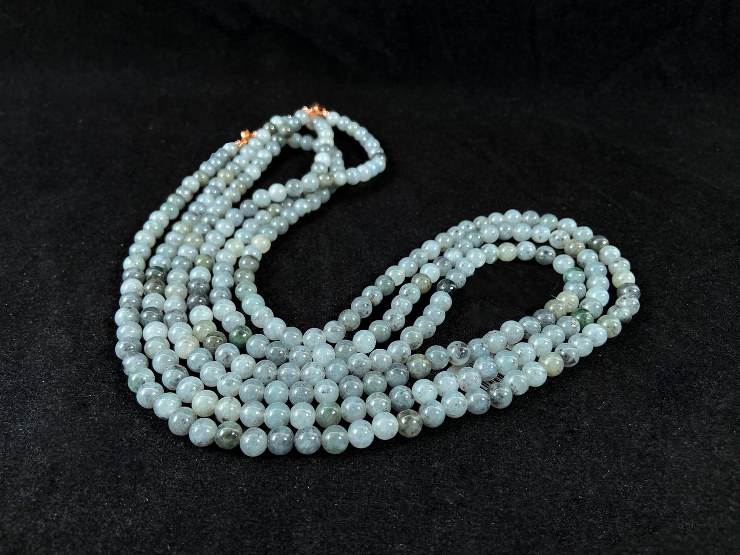 Semi transparent jade beads with unique gray accents, deep green stones, and alloy clasp.