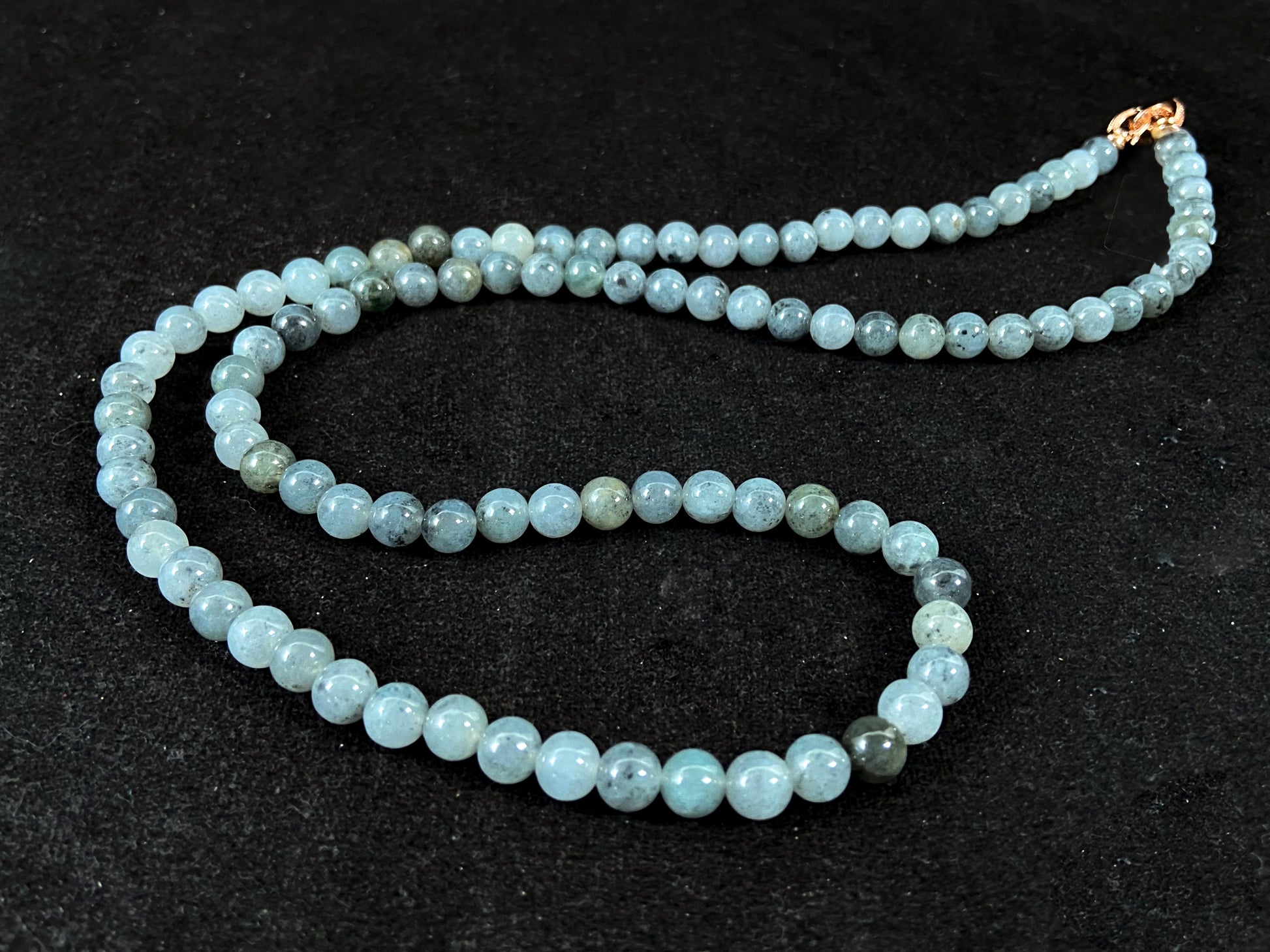 Semi transparent jade beads with unique gray accents, deep green stones, and alloy clasp.