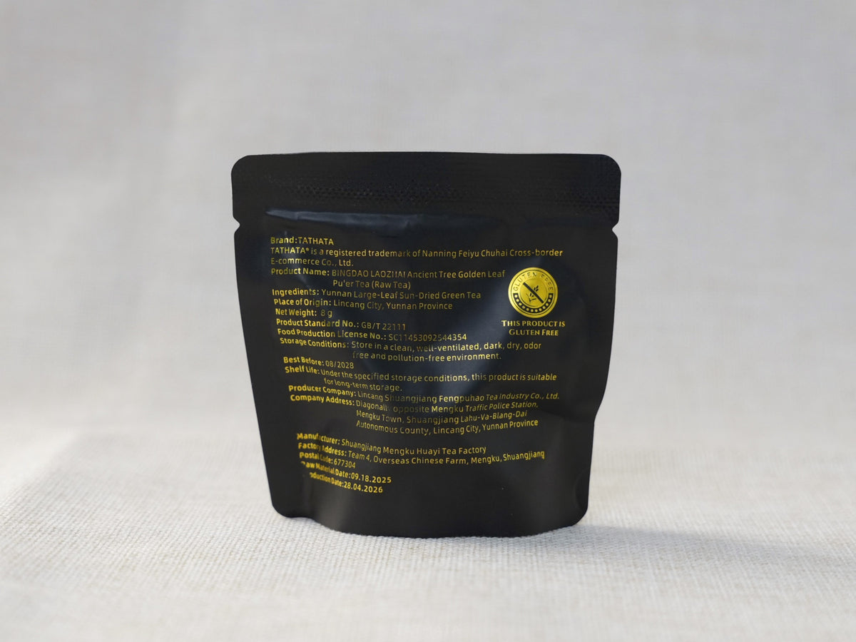 The back of the individual black tea sachet displays product specifications for "TATHATA Iceland Old Village Ancient Tree Golden Leaf Raw Pu-erh Tea" (a gluten-free Yunnan loose-leaf tea sachet).