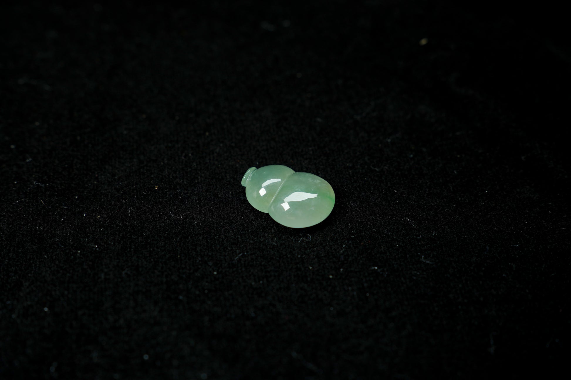 Two green gemstones on a black background