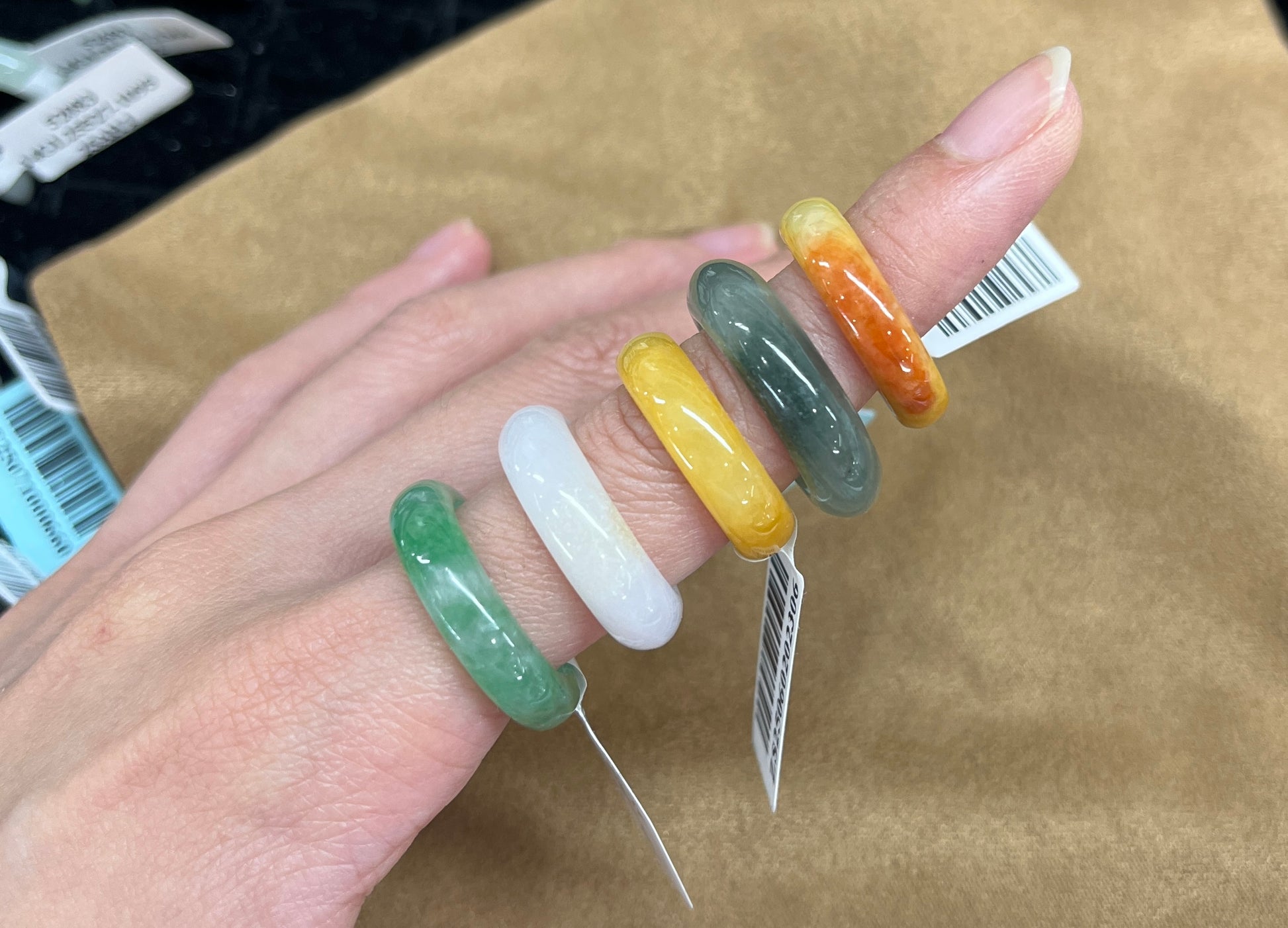 Hand wearing colorful jadeite rings 