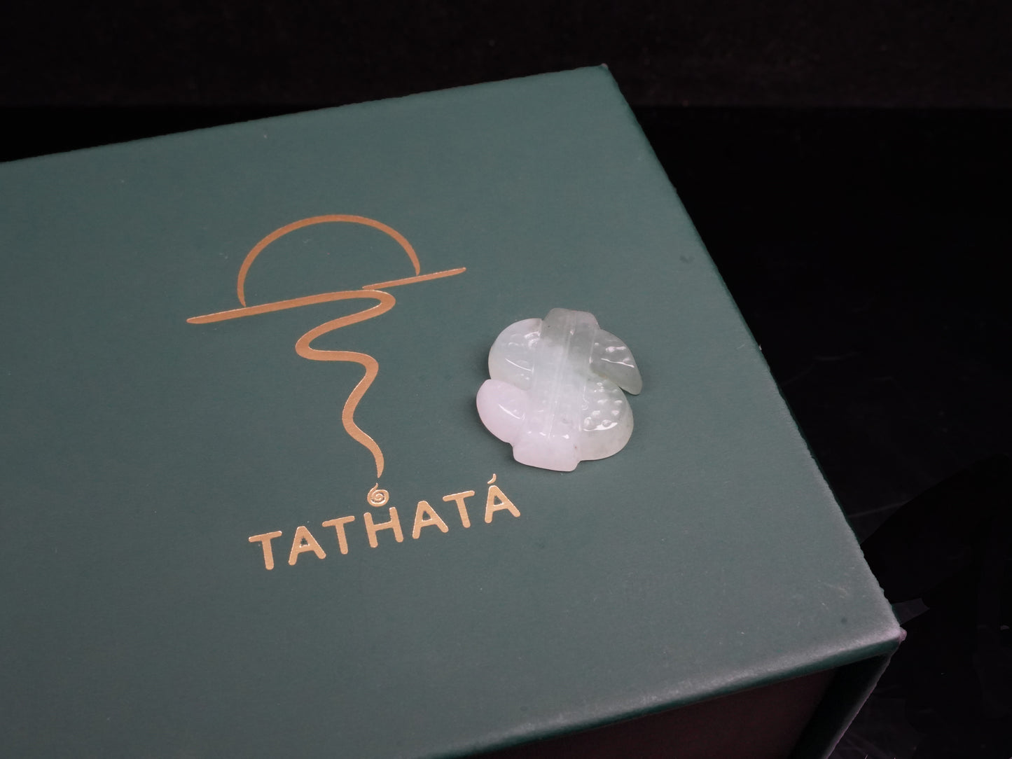 A soft gradient green white dollar symbol loose jadeite.