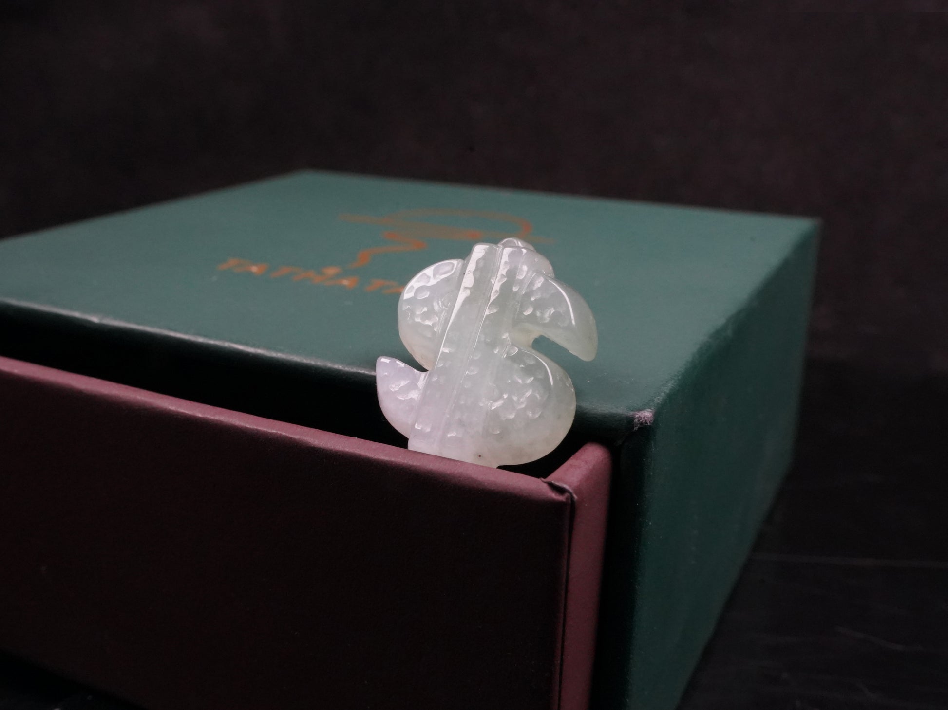 A soft gradient green white dollar symbol loose jadeite.