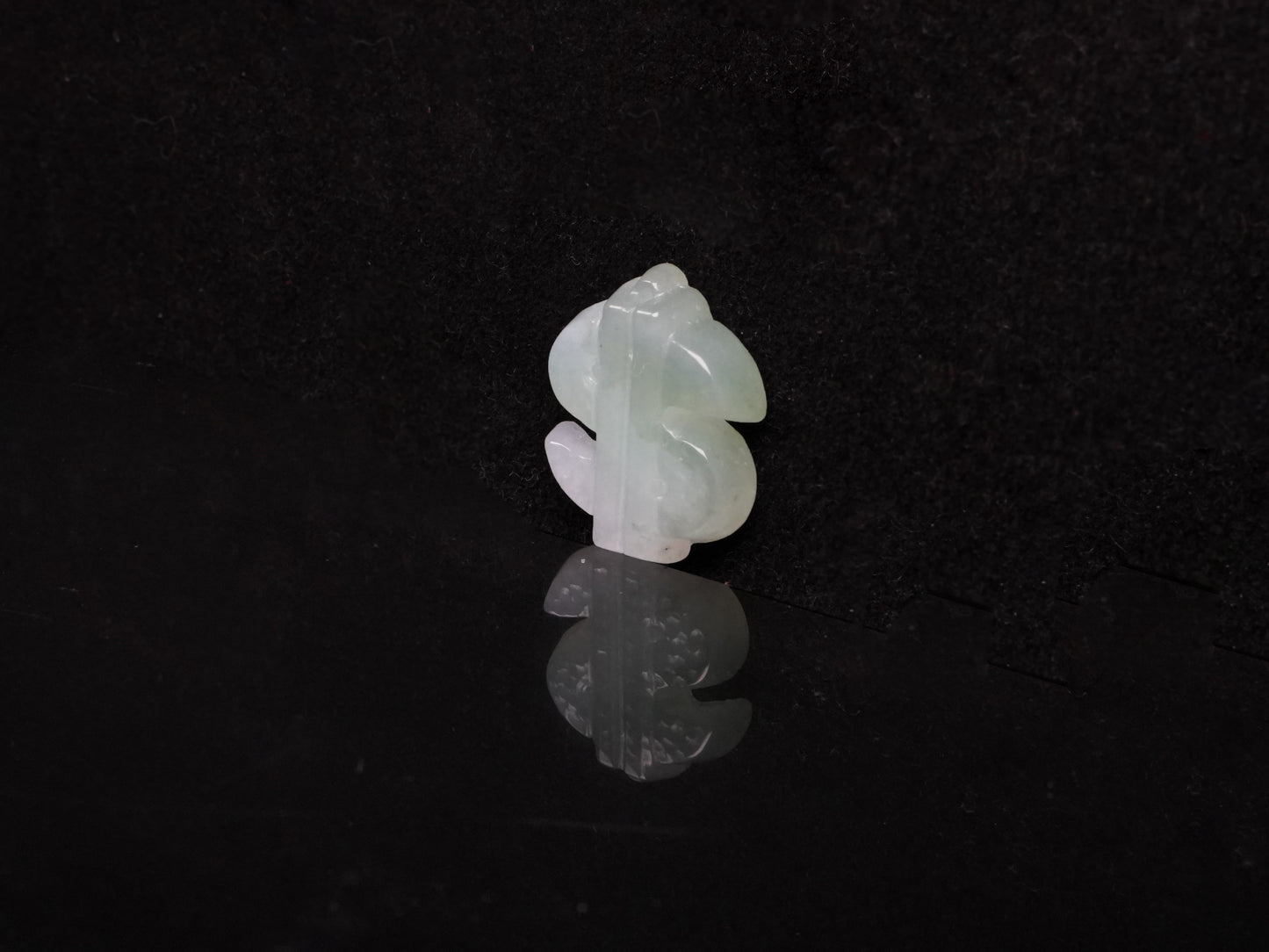 A soft gradient green white dollar symbol loose jadeite.