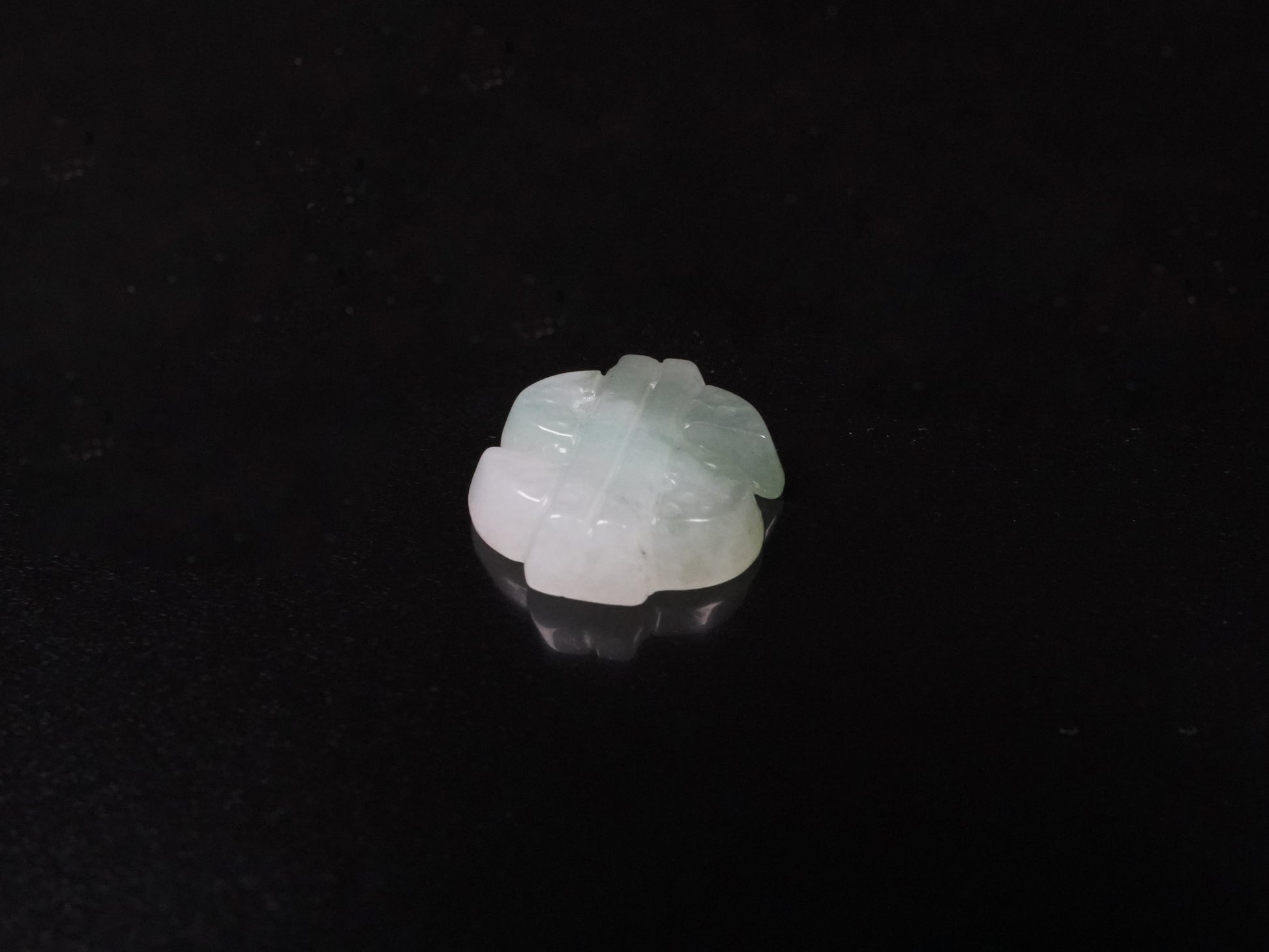 A soft gradient green white dollar symbol loose jadeite.