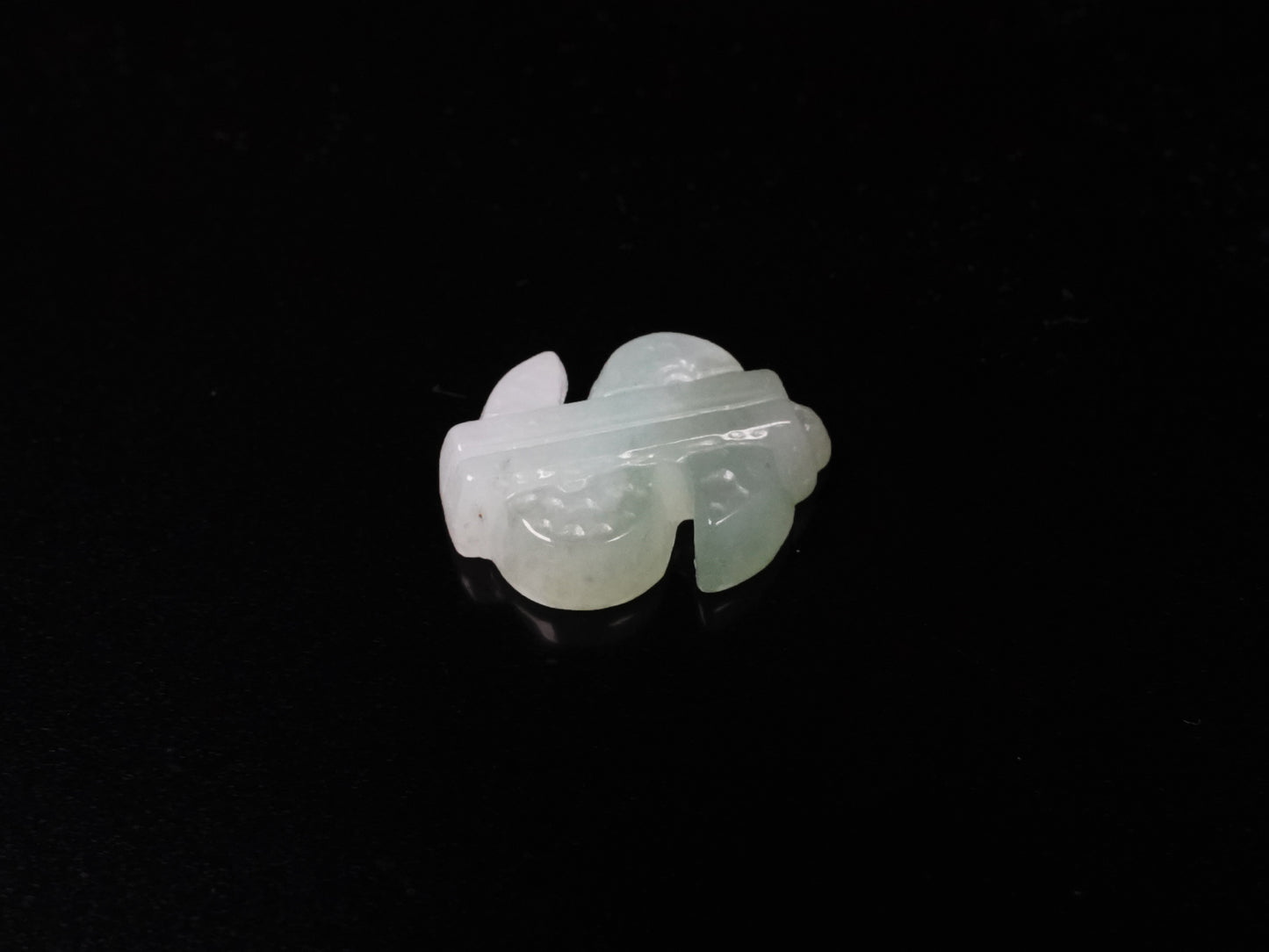 A soft gradient green white dollar symbol loose jadeite.