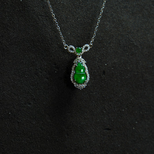 Green gemstone necklace with silver chain on a black background