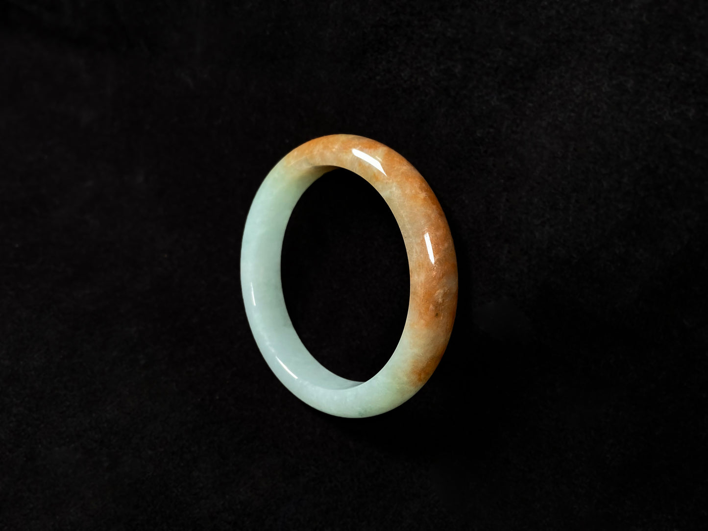 A jadeite bangle where soft mint green gently transitions into warm honey amber.
