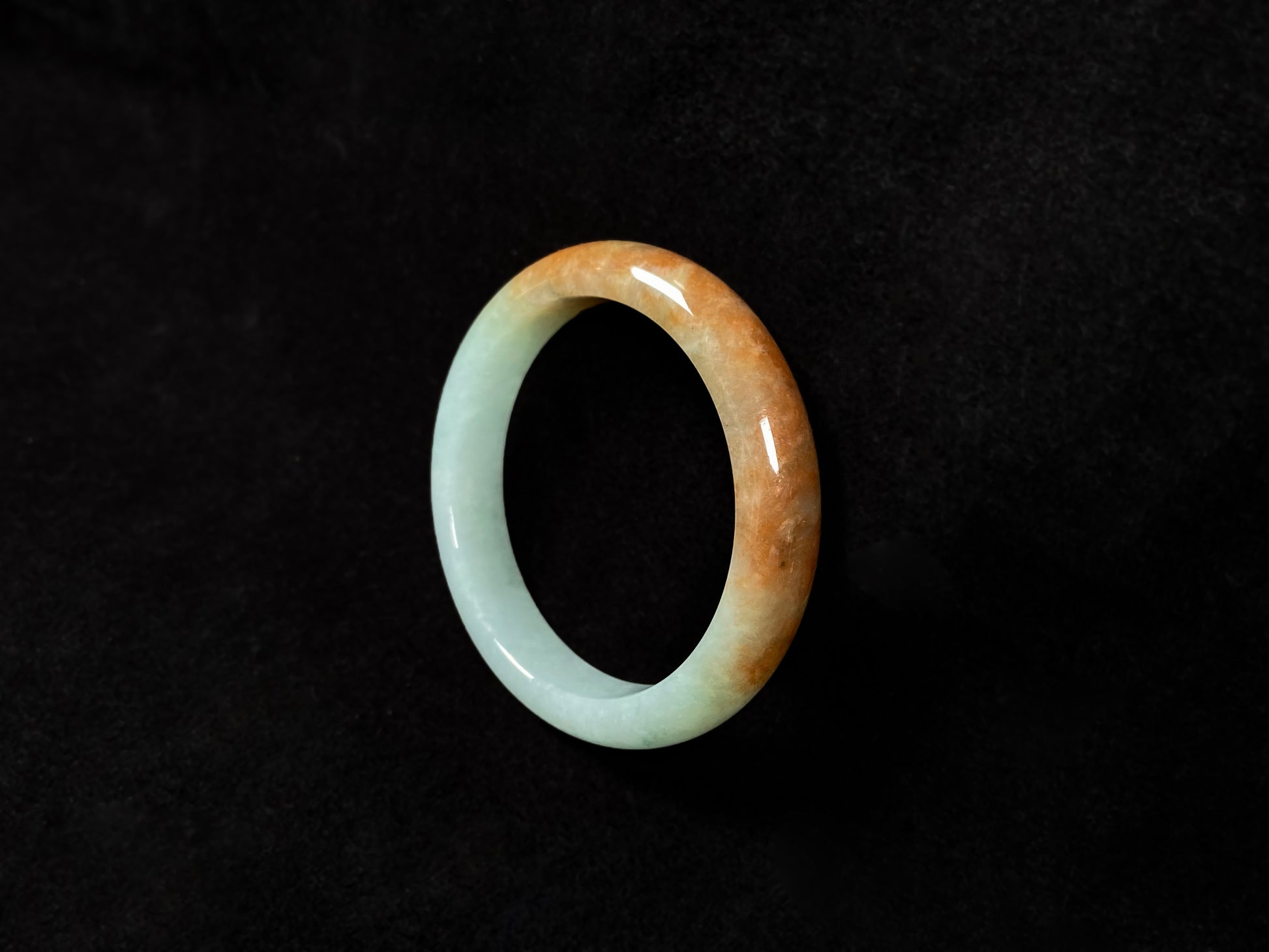 A jadeite bangle where soft mint green gently transitions into warm honey amber.