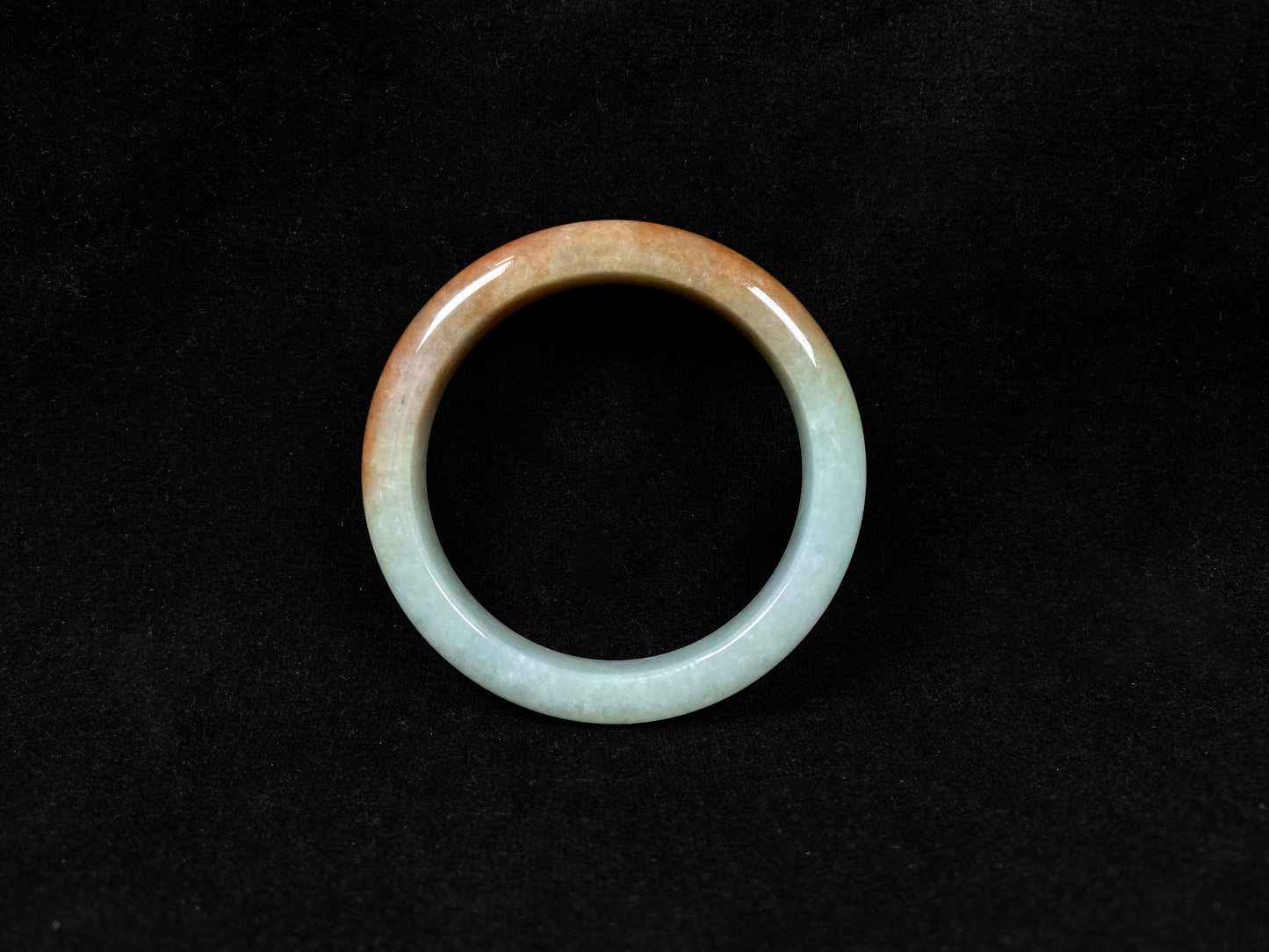 A jadeite bangle where soft mint green gently transitions into warm honey amber.