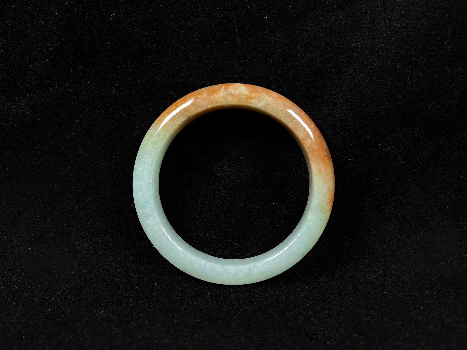 A jadeite bangle where soft mint green gently transitions into warm honey amber.