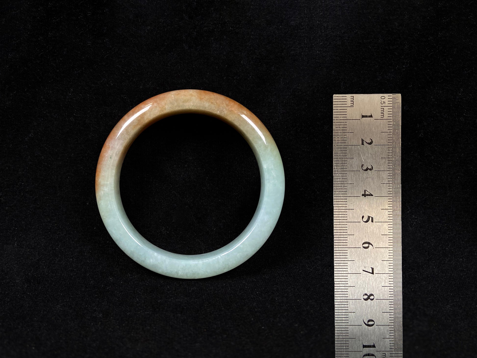 A jadeite bangle where soft mint green gently transitions into warm honey amber.