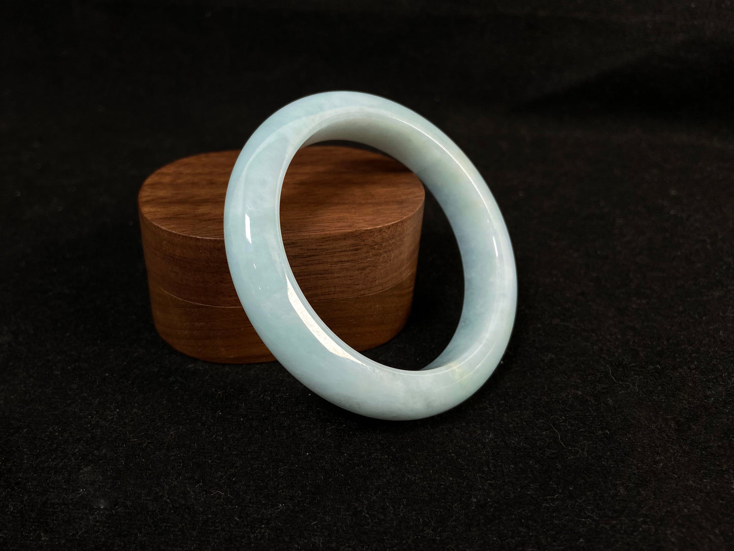 This bracelet showcases a pale green jade with a subtle purple hue.