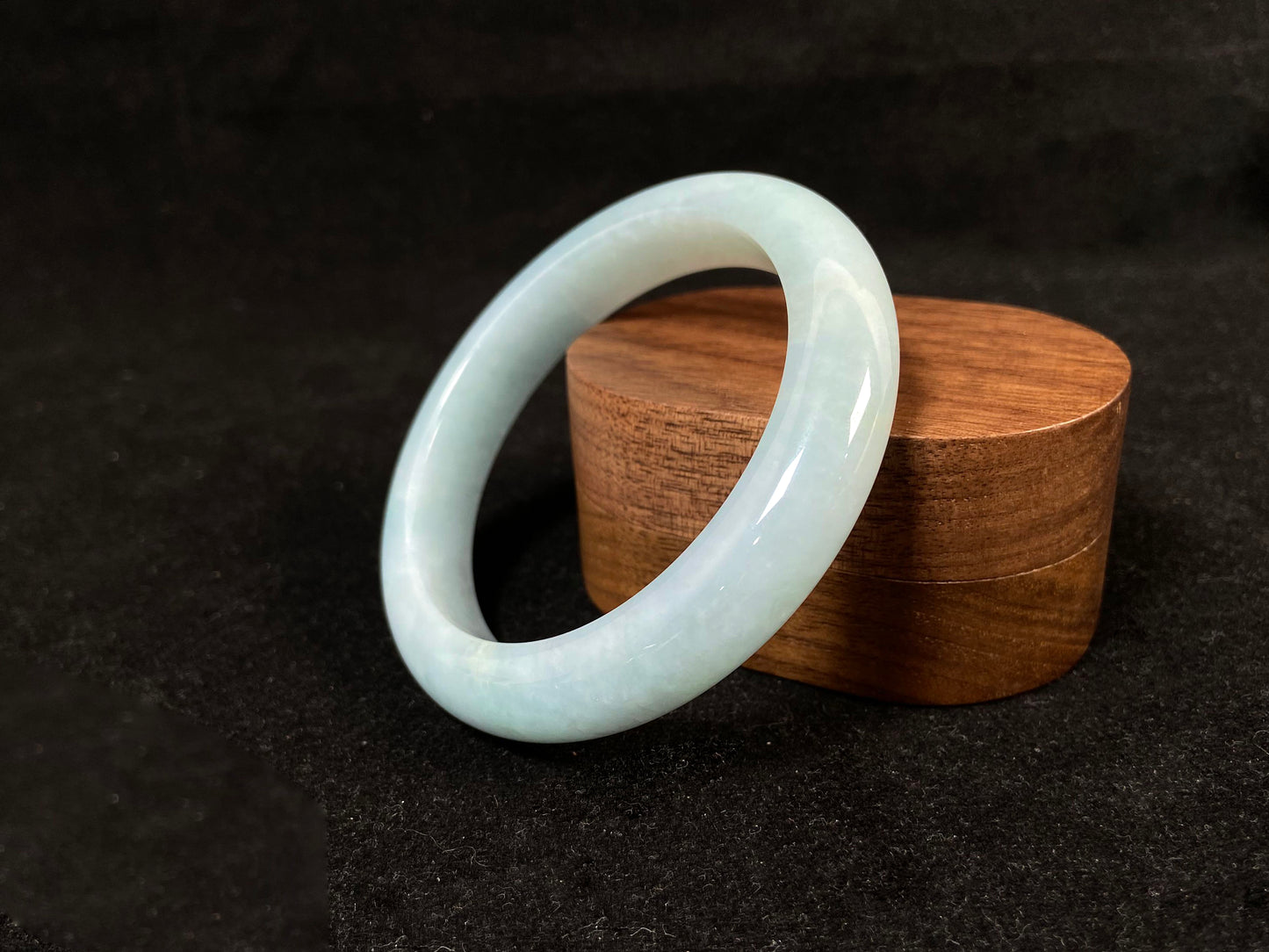 This bracelet showcases a pale green jade with a subtle purple hue.