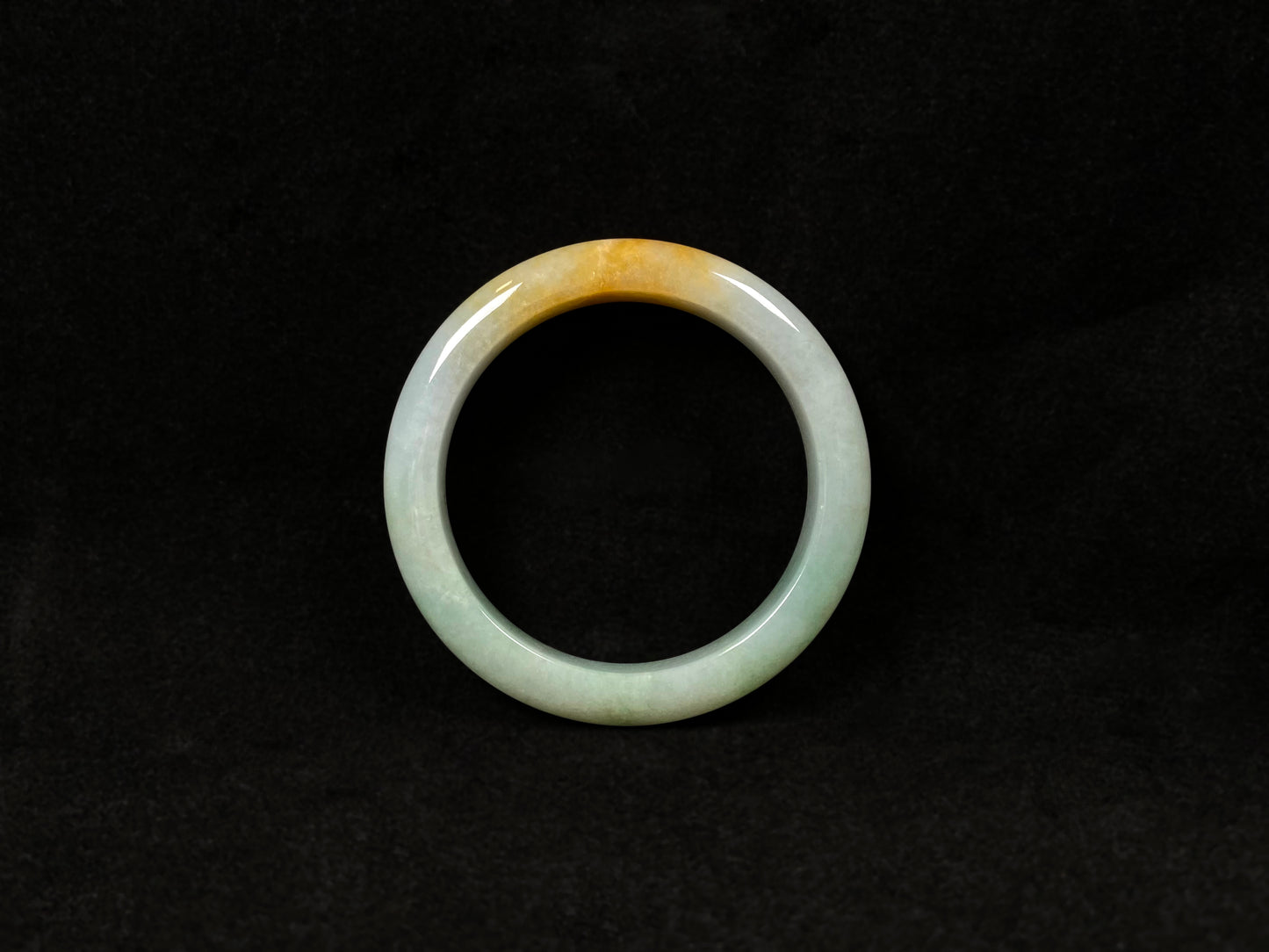 A light green jadeite bangle with a bold splash of gold.