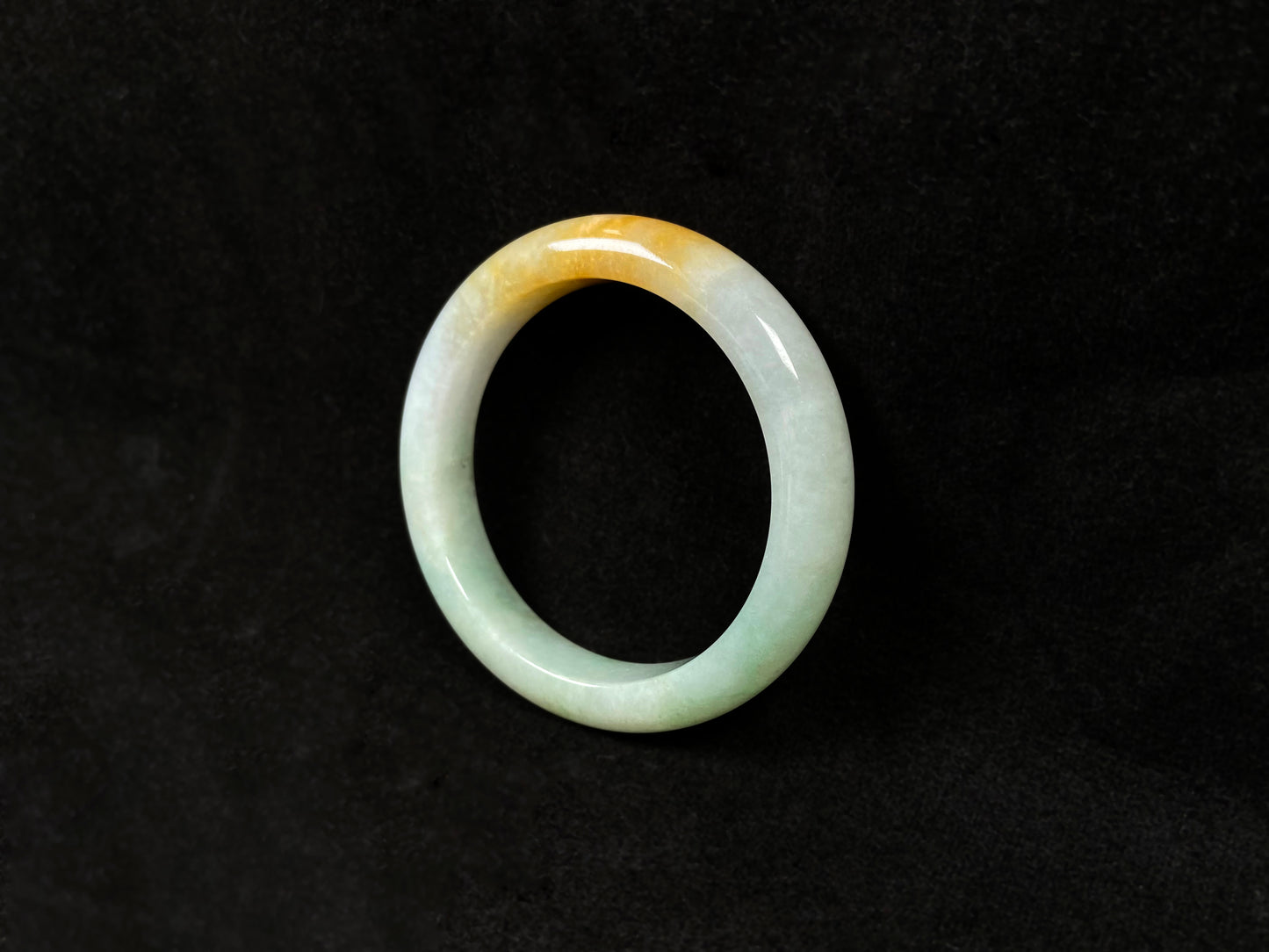 A light green jadeite bangle with a bold splash of gold.