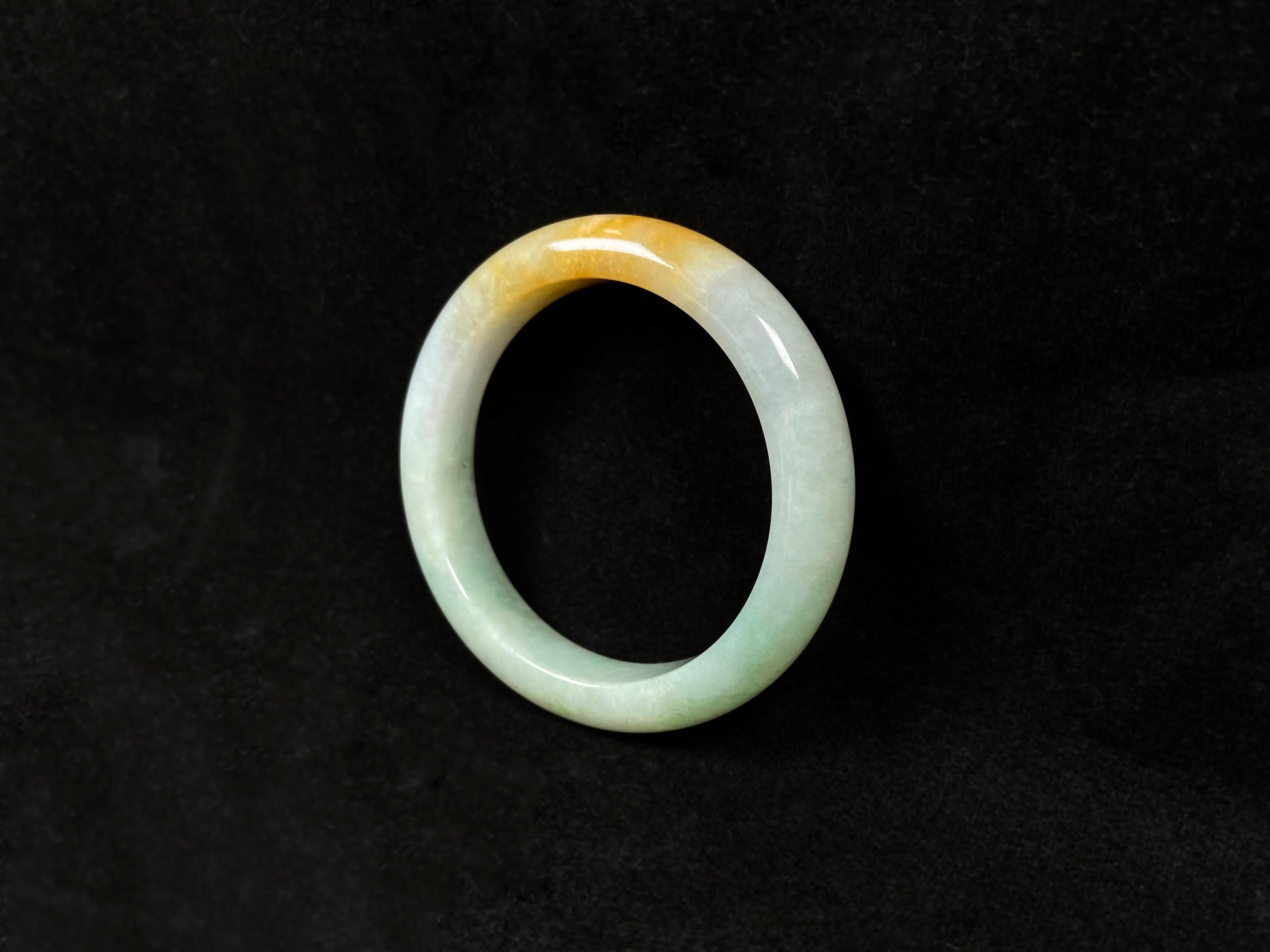 A light green jadeite bangle with a bold splash of gold.