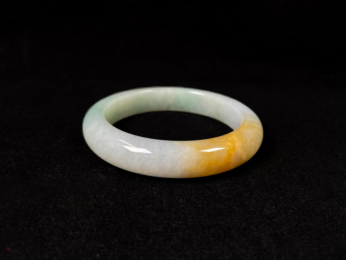 A light green jadeite bangle with a bold splash of gold.