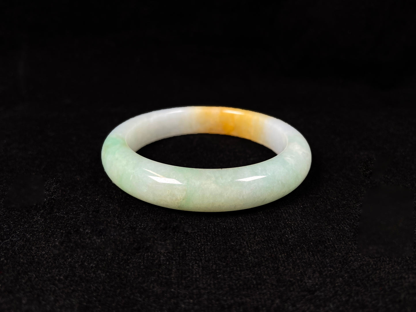 A light green jadeite bangle with a bold splash of gold.