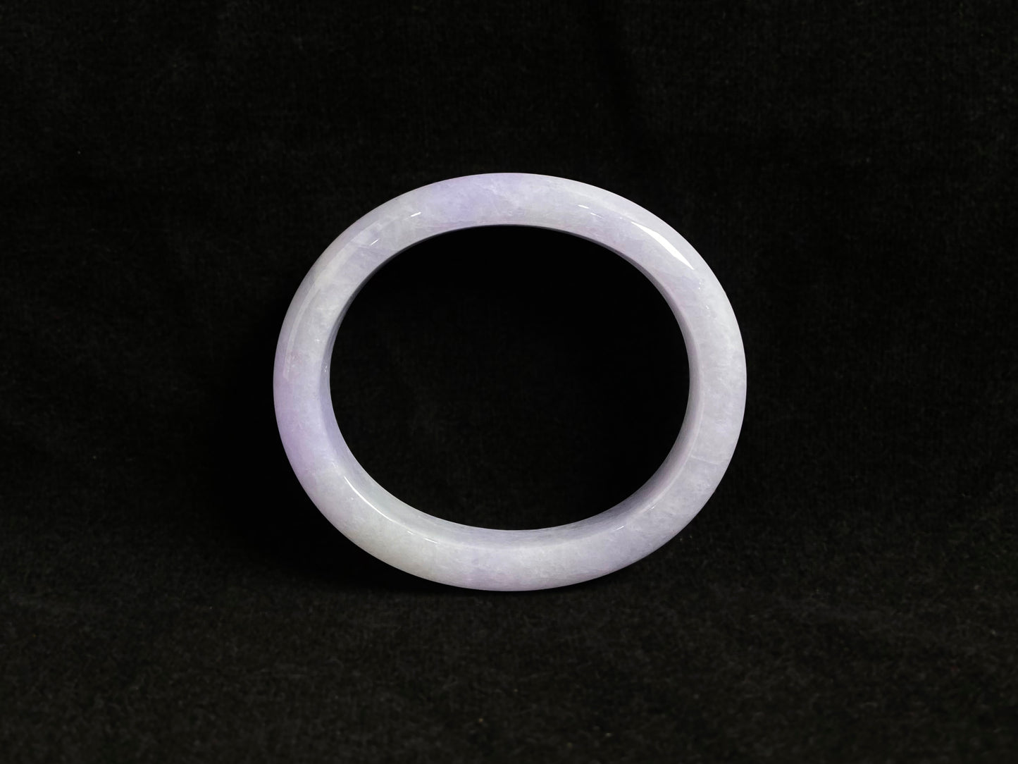 This elegant jade bangle showcases a unique white purple hue with delicate color blending.