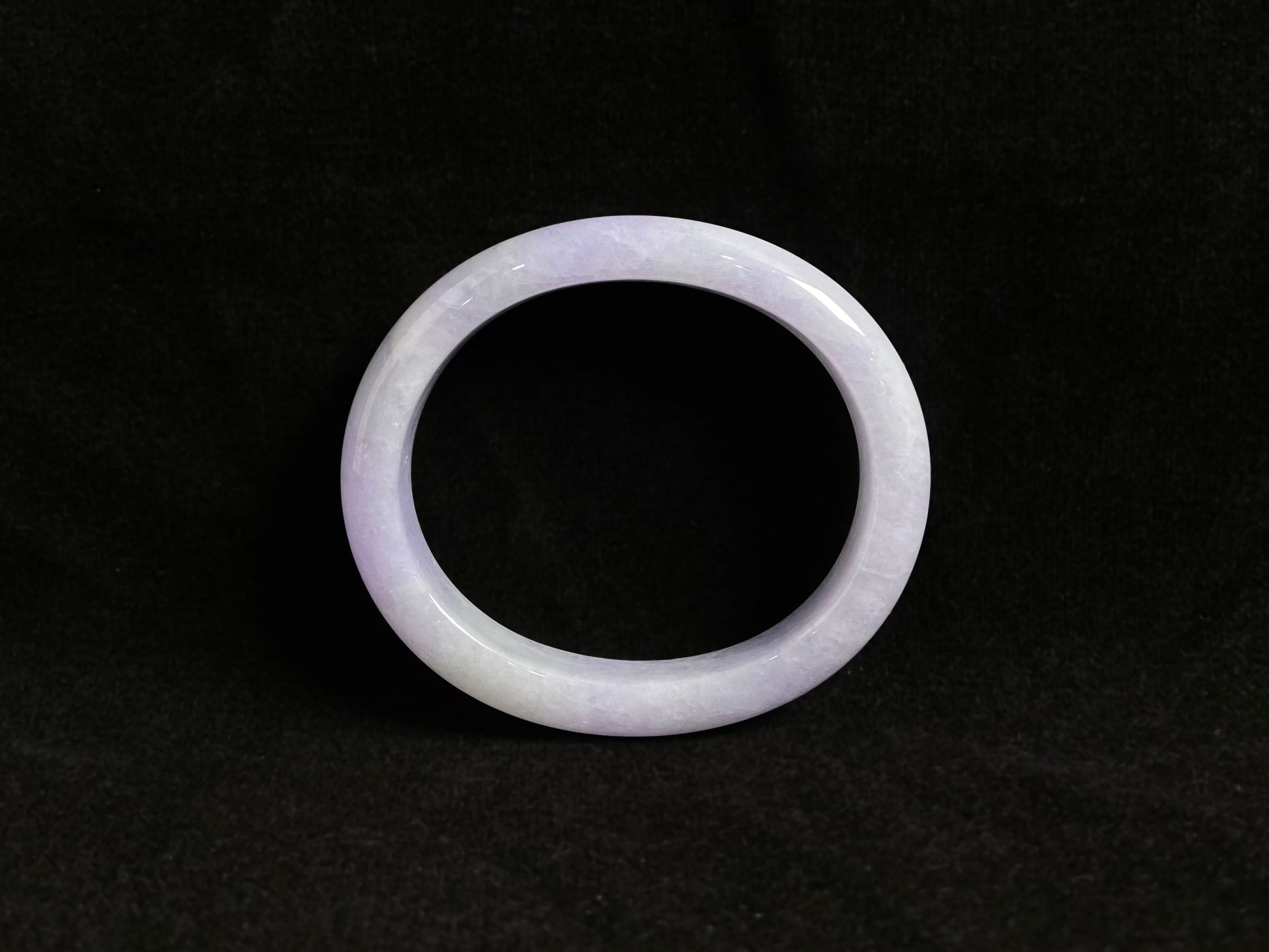 This elegant jade bangle showcases a unique white purple hue with delicate color blending.