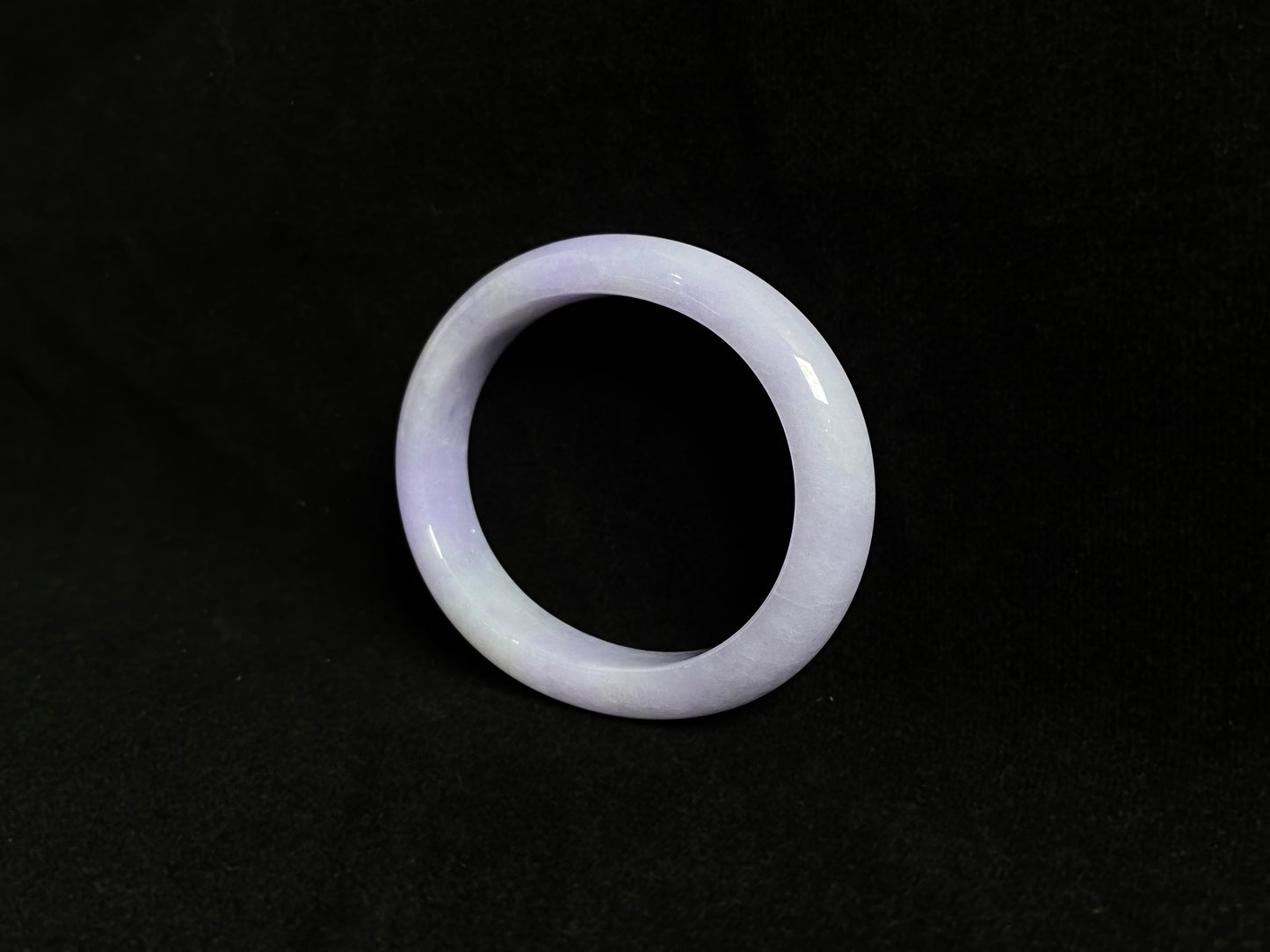 This elegant jade bangle showcases a unique white purple hue with delicate color blending.