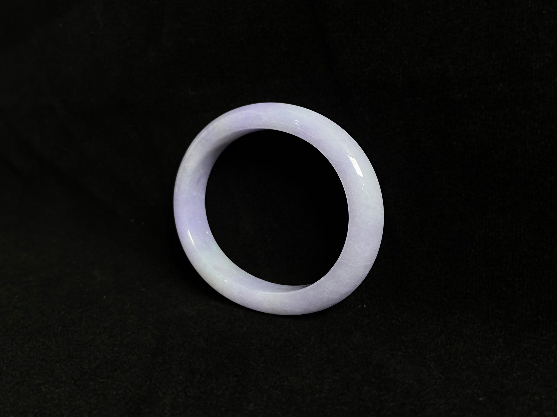 This elegant jade bangle showcases a unique white purple hue with delicate color blending.
