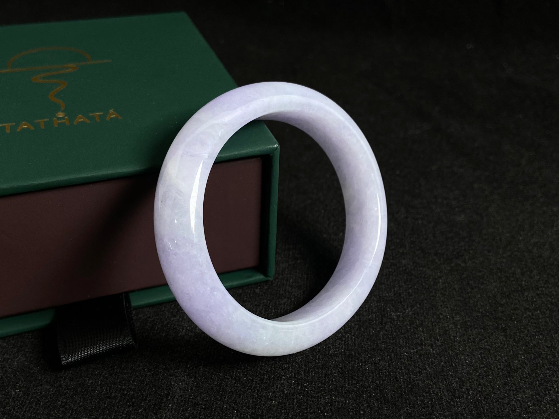 This elegant jade bangle showcases a unique white purple hue with delicate color blending.