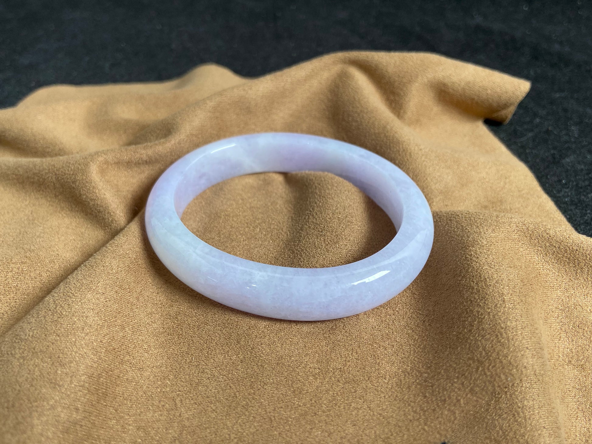 This elegant jade bangle showcases a unique white purple hue with delicate color blending.