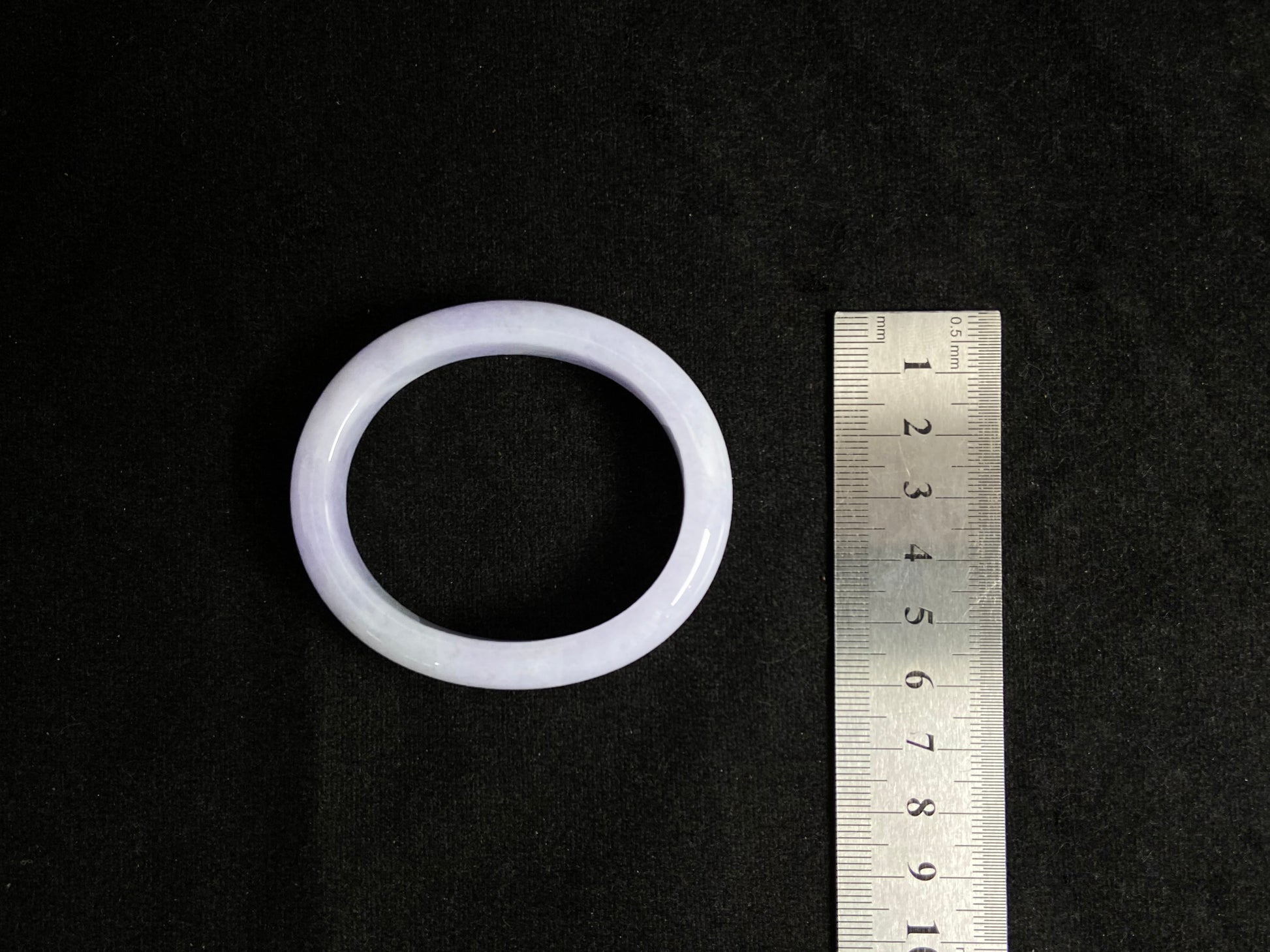 This elegant jade bangle showcases a unique white purple hue with delicate color blending.