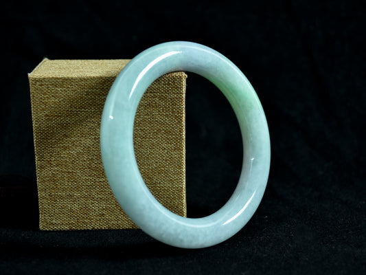 Jade bracelet on a dark background with a textured box